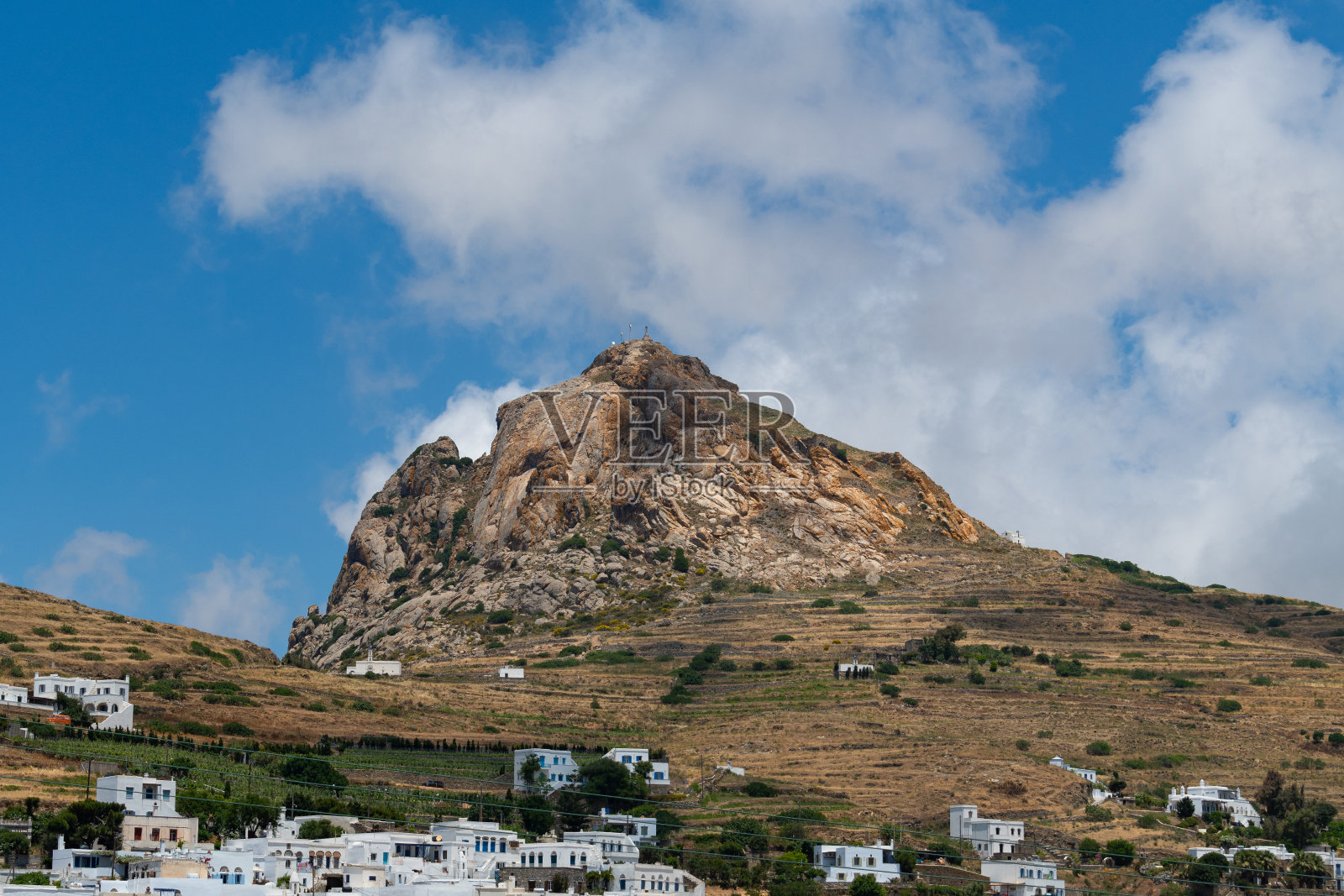 Exomburg (Xomburgo)位于蒂诺斯岛中心的岩石山,山下有传统的村庄照片摄影图片