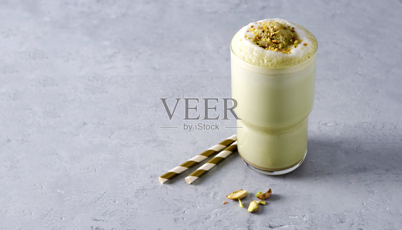 抹茶咖啡泡沫和坚果撒在灰色的混凝土背景与复制空间照片摄影图片