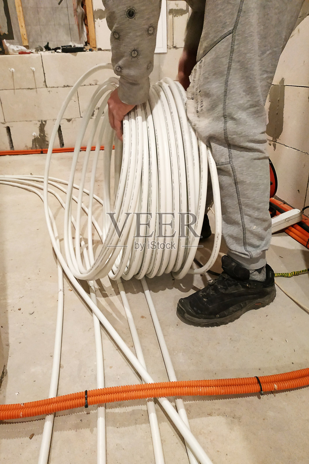 在地板上安装加热管,将加热管带到集热器。照片摄影图片