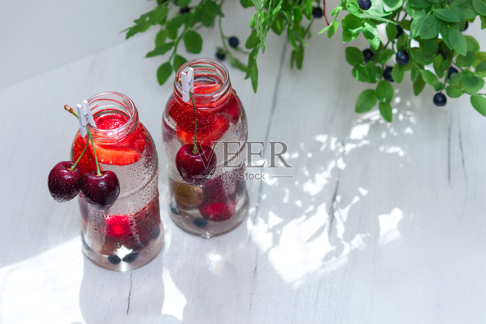 各种水果与排毒水在玻璃小瓶。清爽的夏季饮料。健康饮食的概念。照片摄影图片