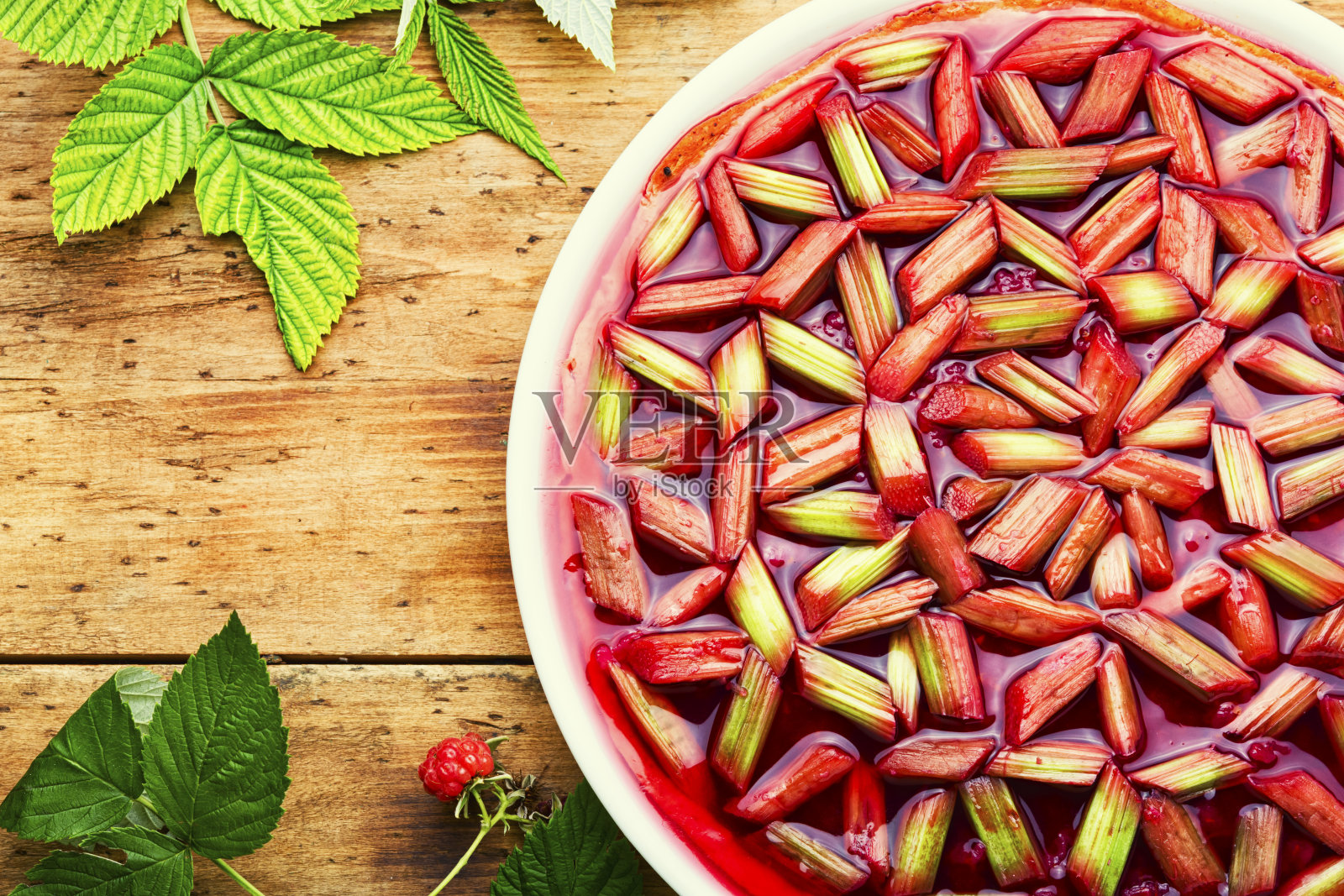 以老木头为背景的大黄和覆盆子派照片摄影图片