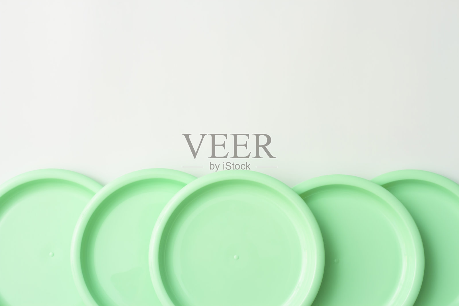 在白色背景上的薄荷色塑料盘子照片摄影图片