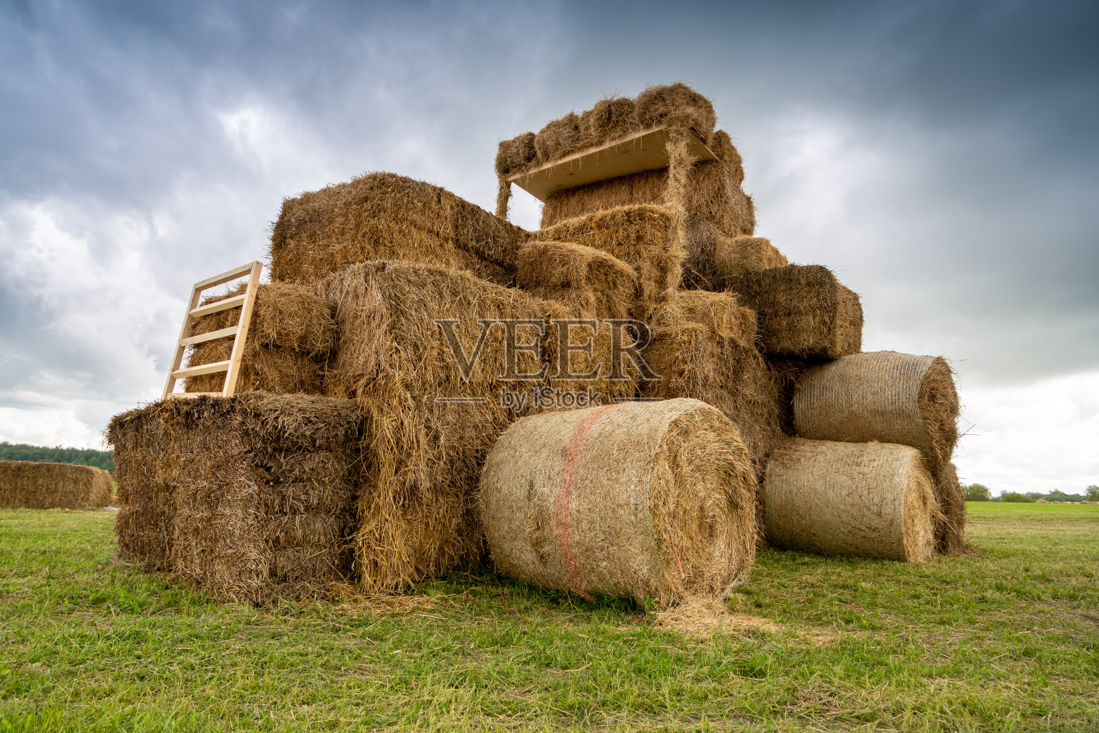 拖拉机从田里的草捆中牵引出来照片摄影图片