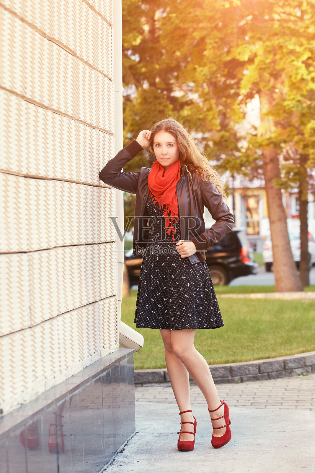 年轻女子站在墙边。户外女性肖像照片摄影图片