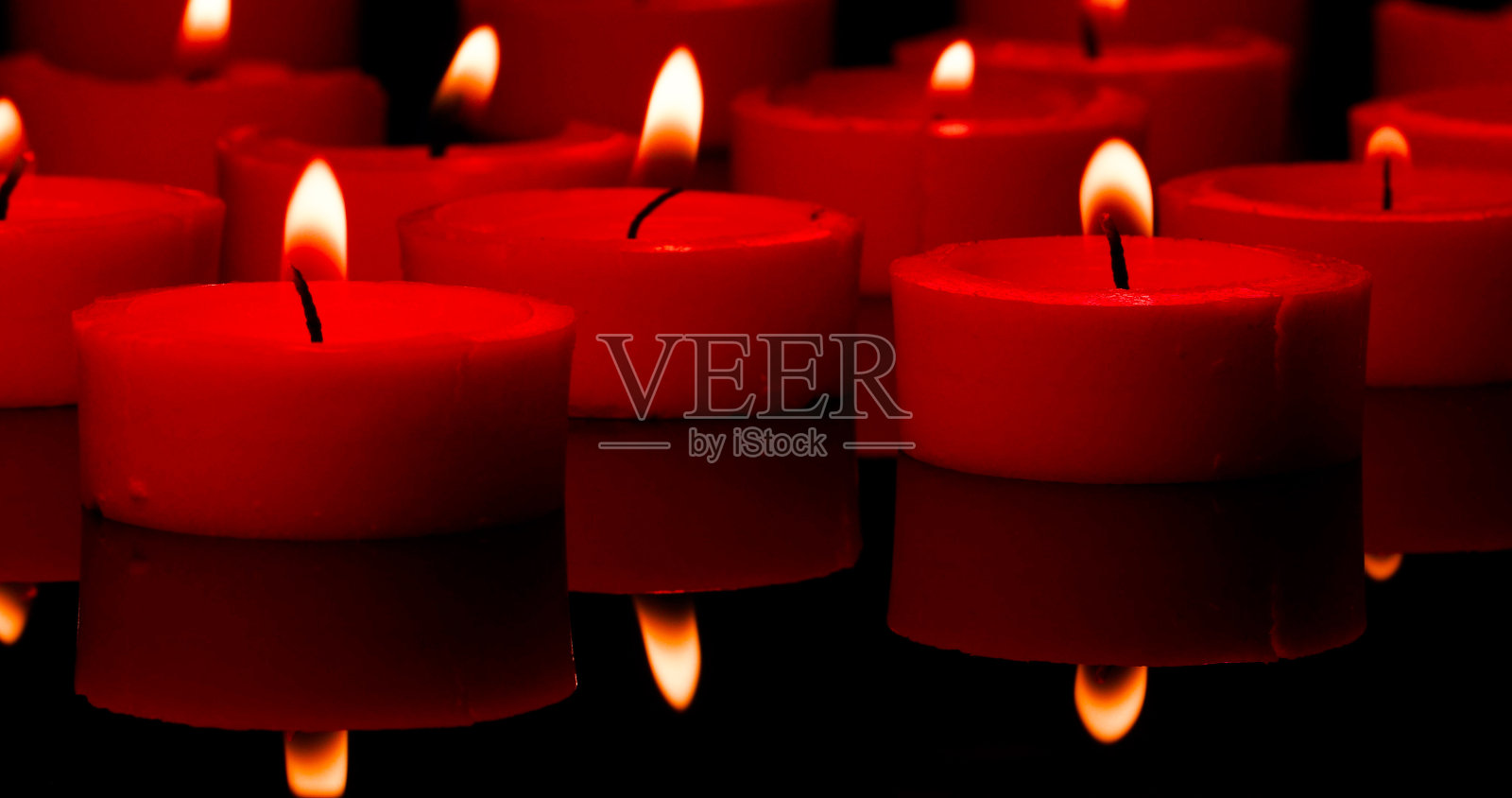 燃烧的红蜡烛。蜡烛反射和蜡烛火。照片摄影图片