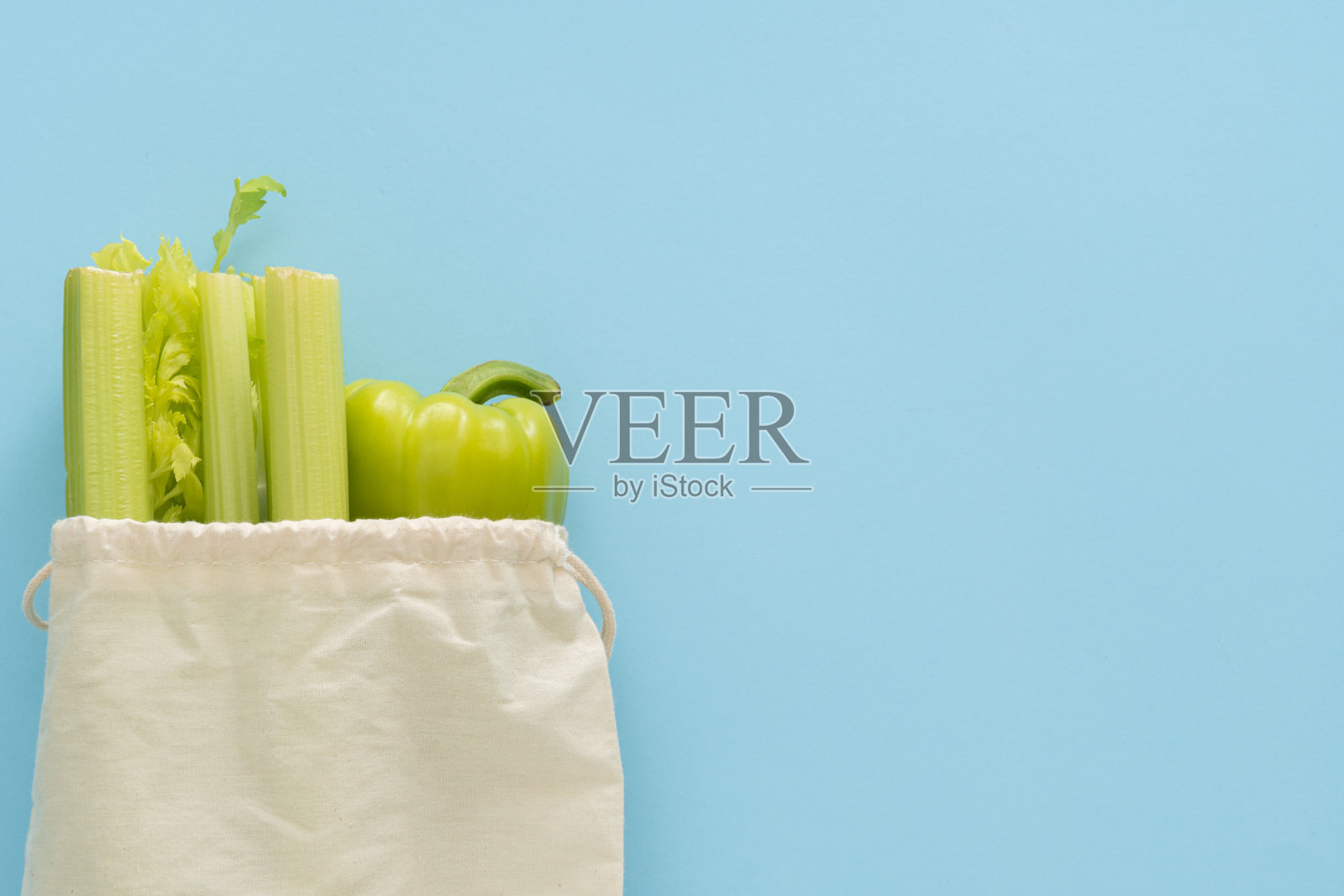 配送健康食品背景。纯素素食食品在生态棉袋蔬菜在蓝色的背景。杂货店购物食品超市和清洁饮食的概念。前视图。文本的地方照片摄影图片