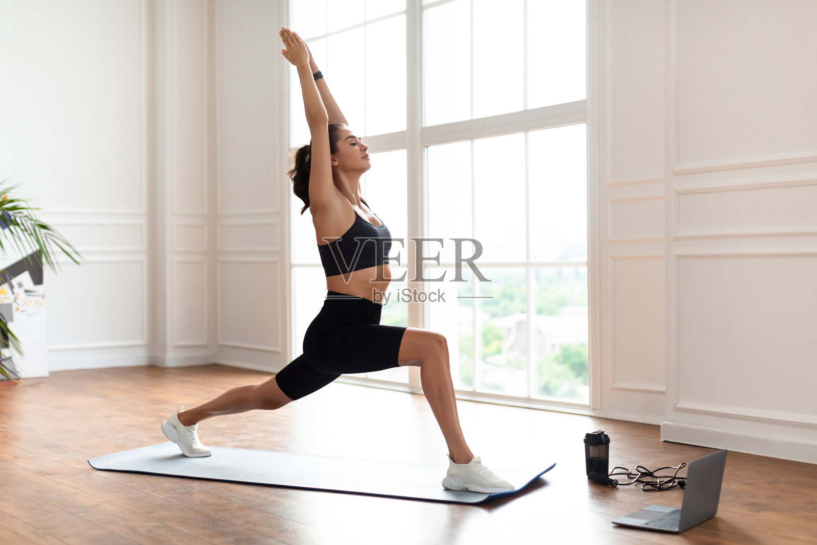 年轻女子在笔记本电脑前做前弓步照片摄影图片