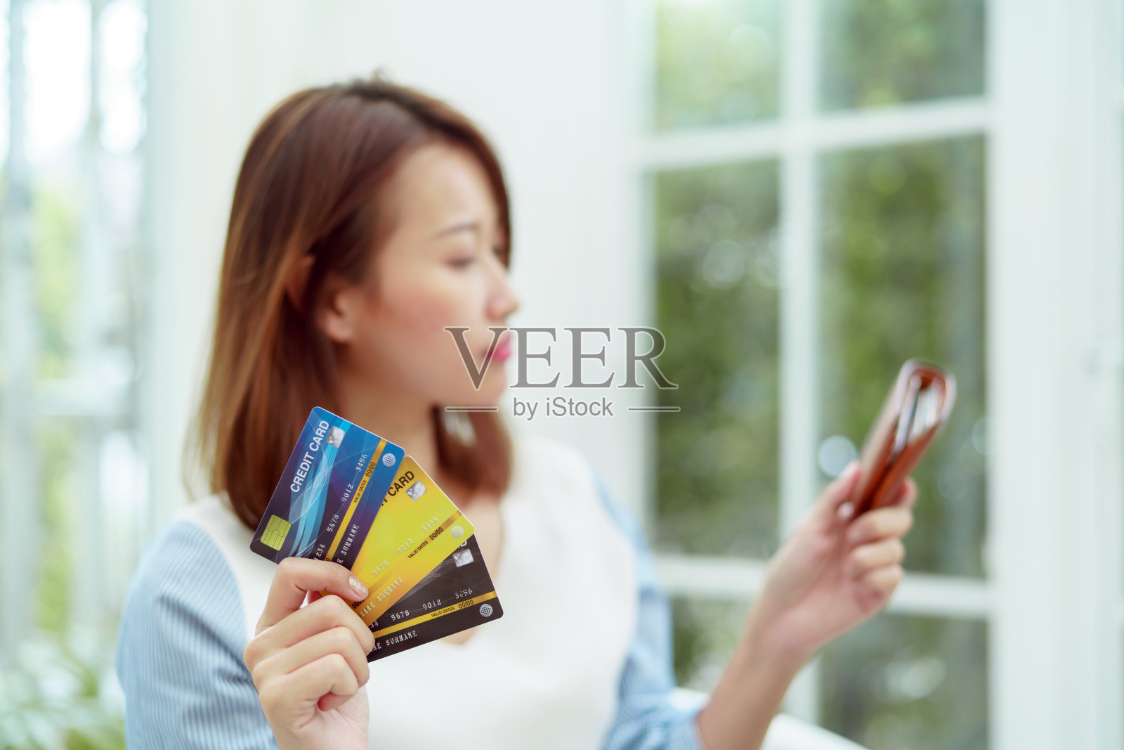 几张信用卡是在一个美丽的亚洲女人的手与女人的焦点。快乐的笑脸准备网上购物。照片摄影图片