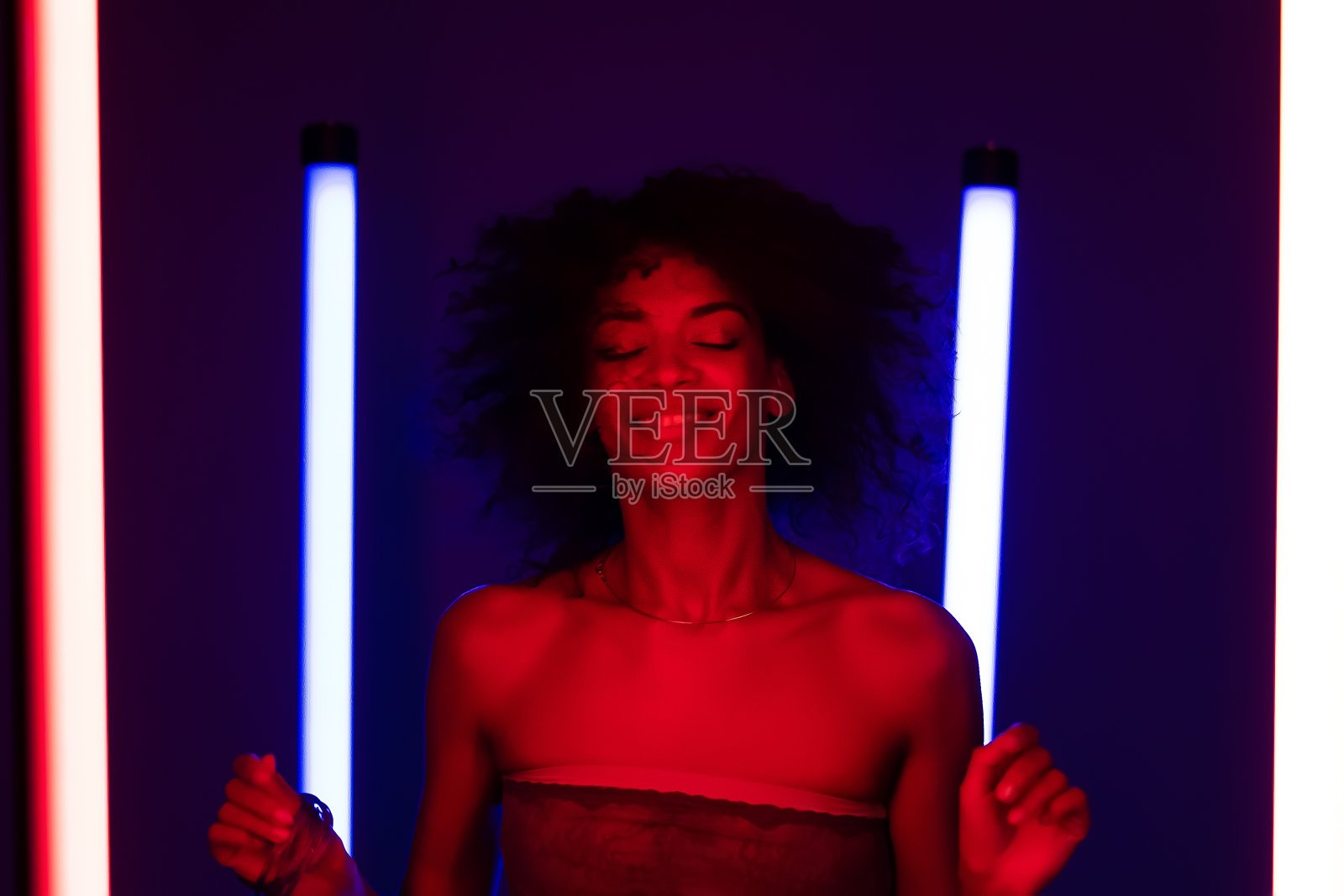 在霓虹灯下跳着很酷的迪斯科舞。多色镜头的女士移动的音乐节奏。千禧年的潮人。方的概念。照片摄影图片