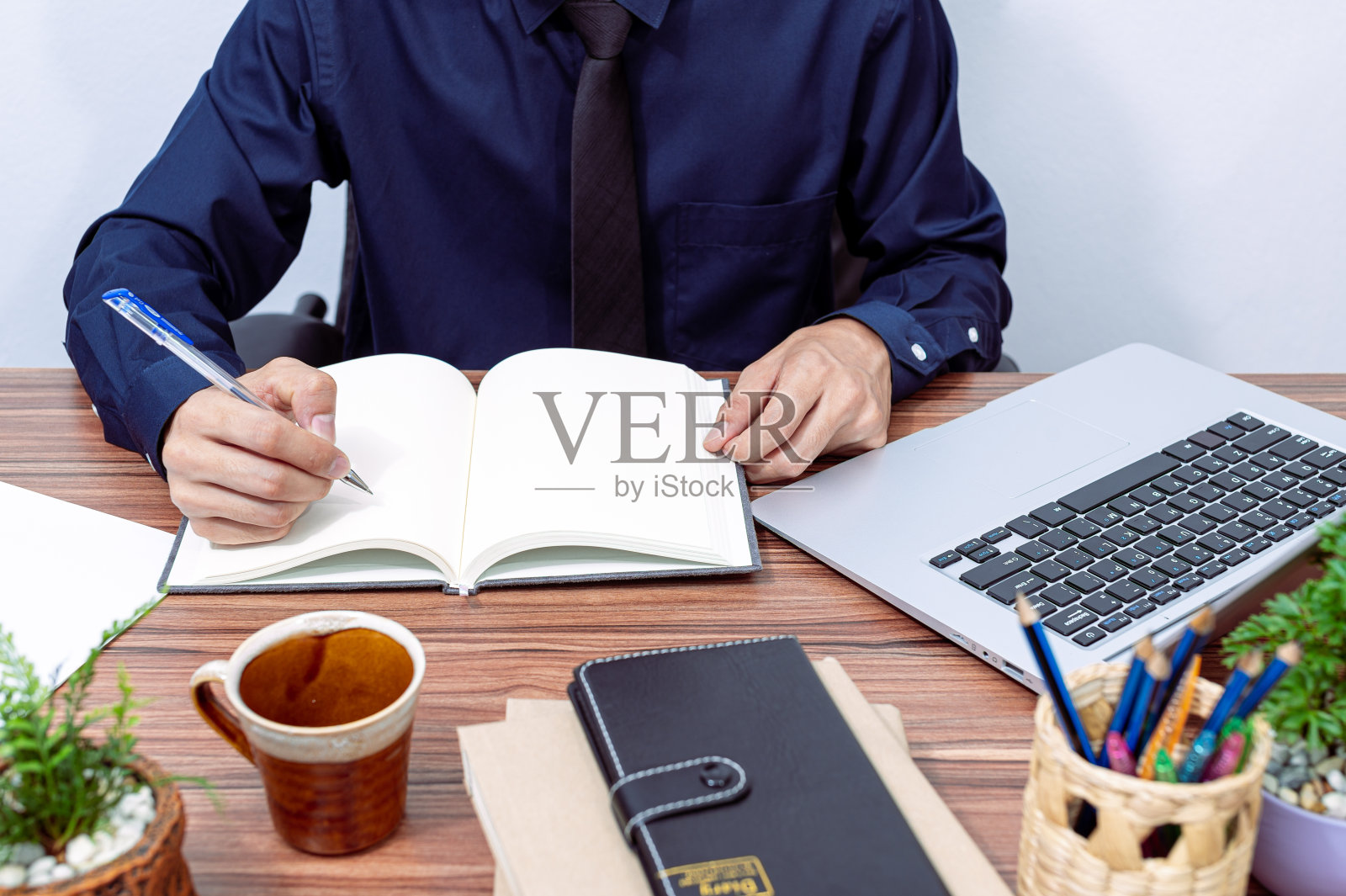 一个商人在书桌前写报告照片摄影图片