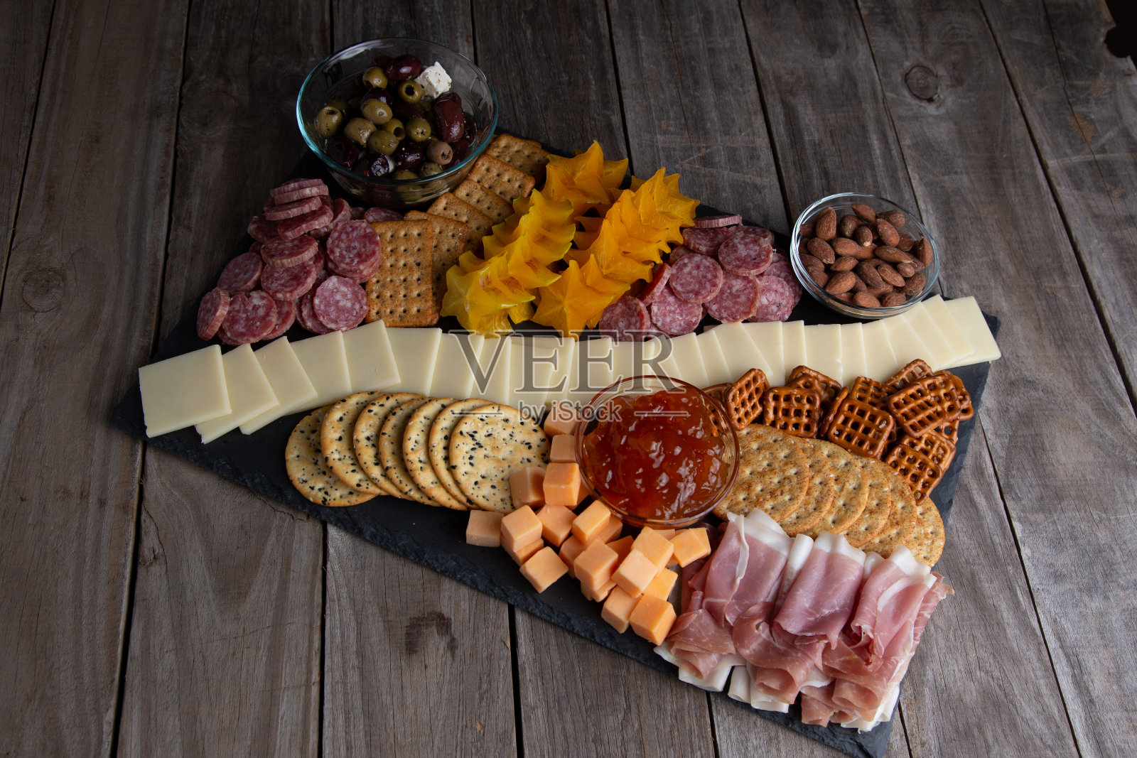 盛满了肉,奶酪,坚果,饼干和杏仁。照片摄影图片