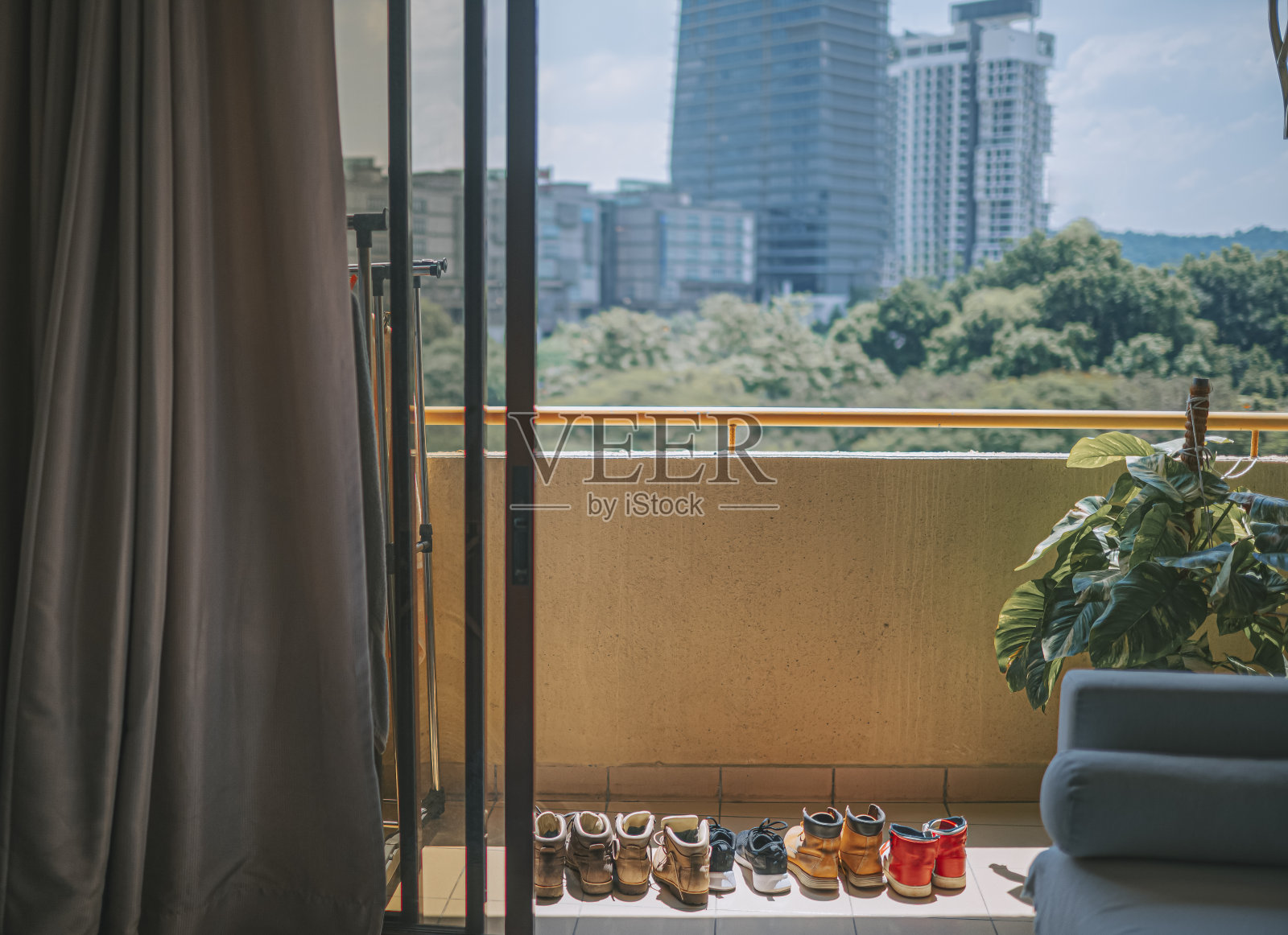 一排鞋在炎热的太阳下在阳台旁边房子植物高角度视图一排鞋在炎热的太阳下在阳台旁边房子植物照片摄影图片