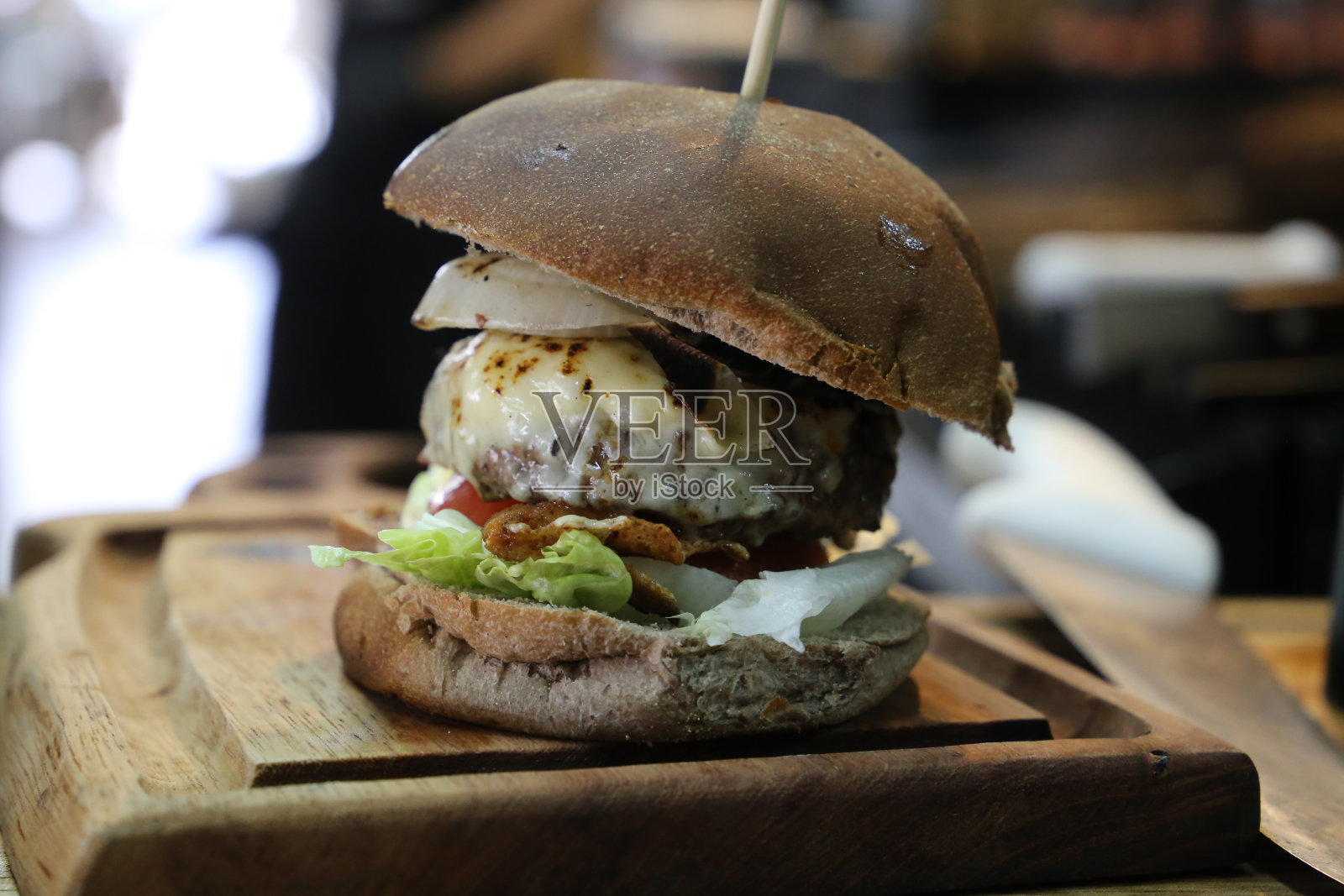 芝士汉堡配芝士,番茄和面包在烧烤。侧视图。近距离照片摄影图片