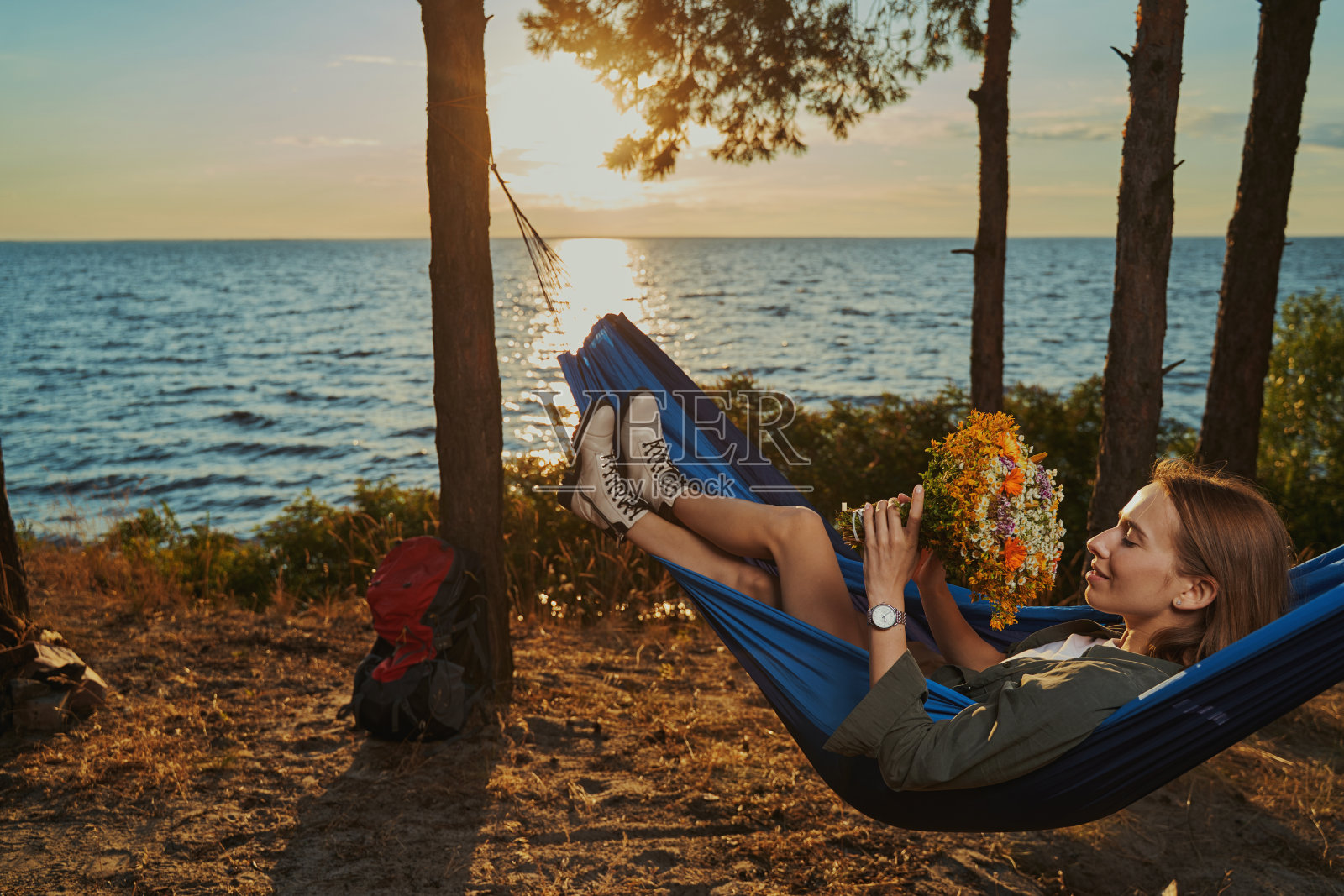 旅客在吊床上休息,享受着花香照片摄影图片