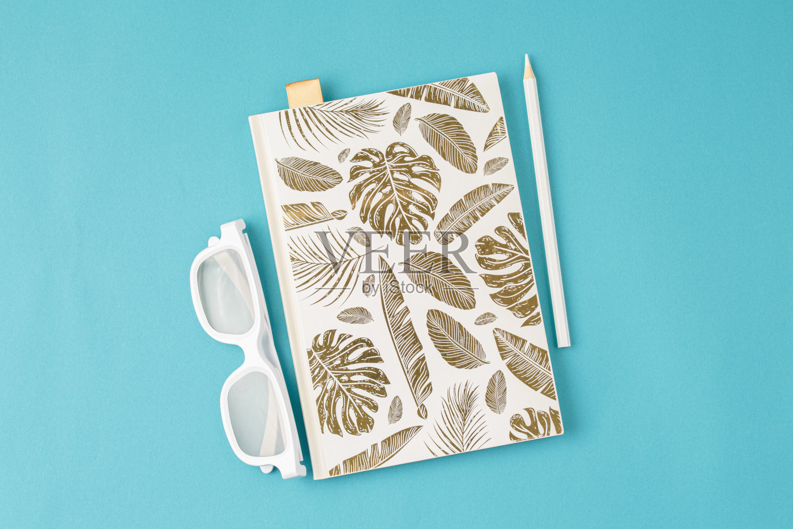 白色记事本,眼镜,铅笔,蓝色背景照片摄影图片