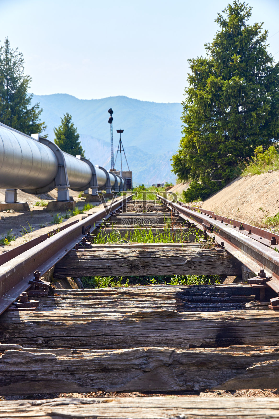 废弃的铁路沿着管道从一座山照片摄影图片