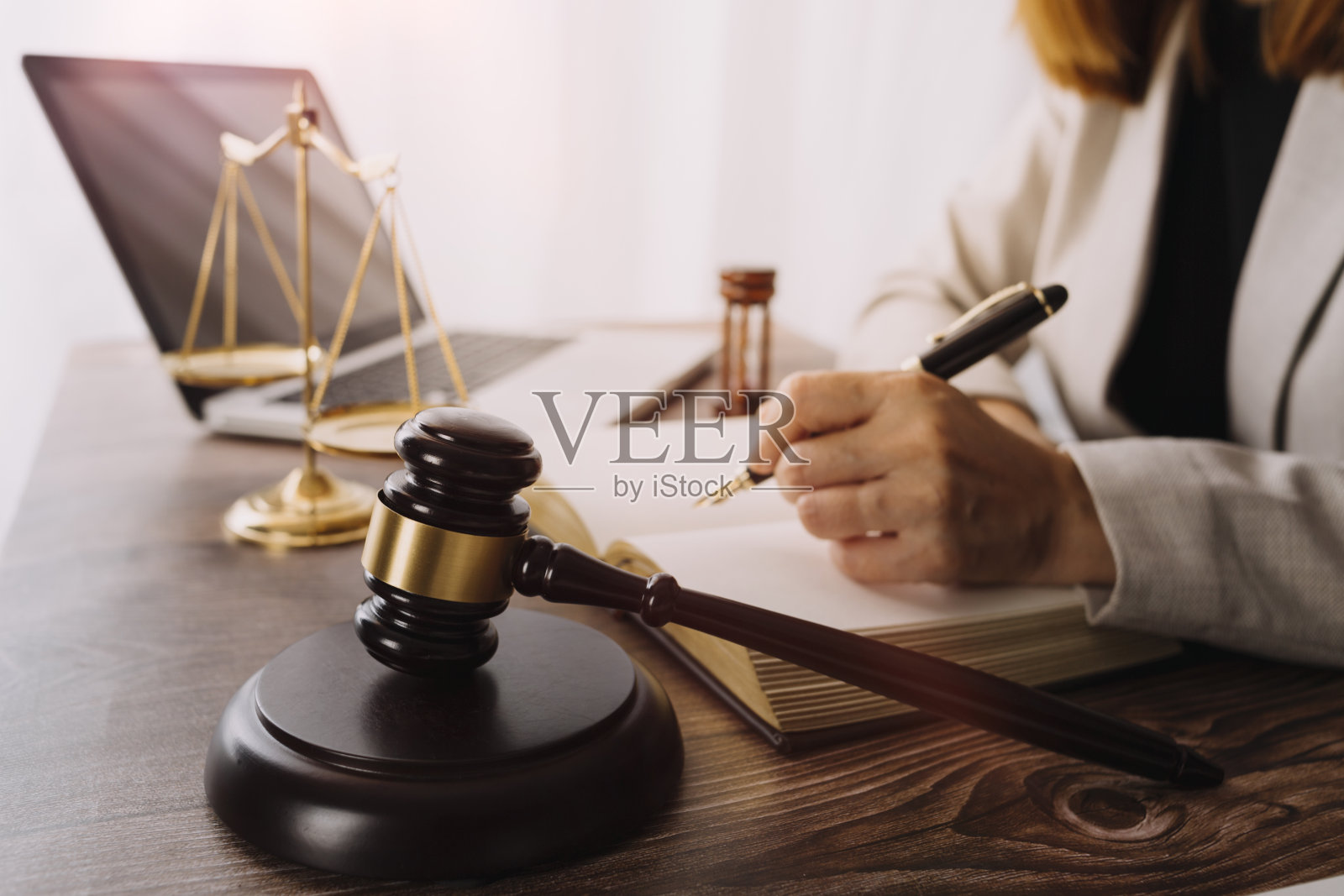 商业和律师在办公室的办公桌上用黄铜秤讨论合同文件。法律、法律服务、法律咨询、司法和法律概念画面具有胶片颗粒效应照片摄影图片