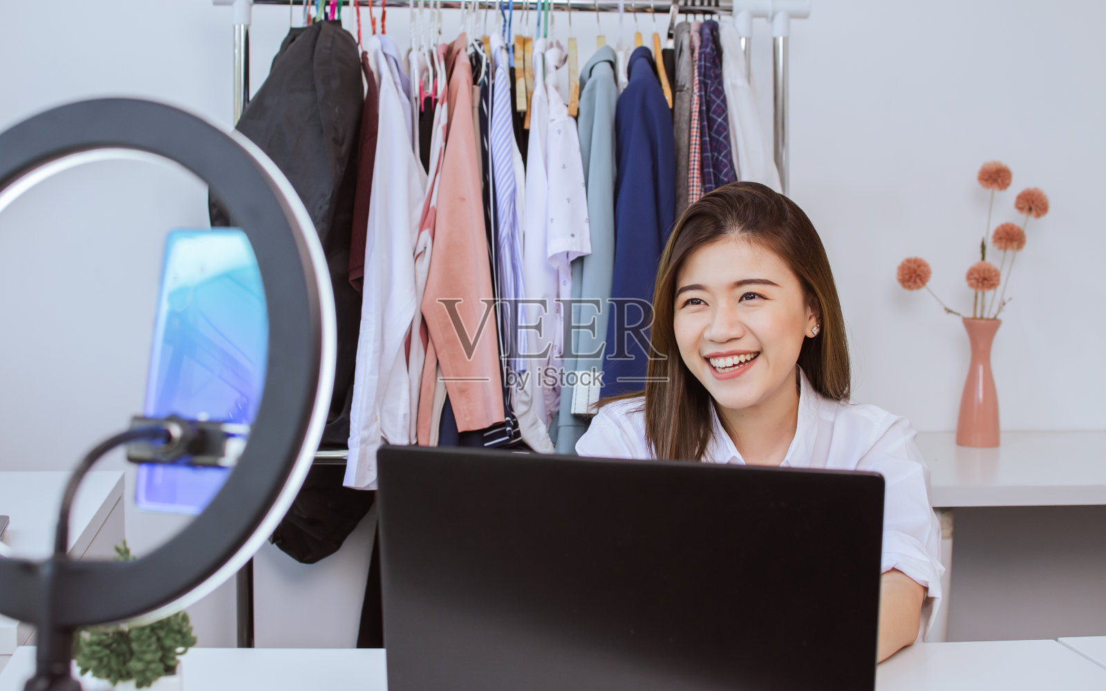 美丽快乐时髦休闲的亚洲女人,在舒适的室内,用手机,笔记本电脑,录制流媒体直播视频,并作为影响者发布在社交媒体上。照片摄影图片