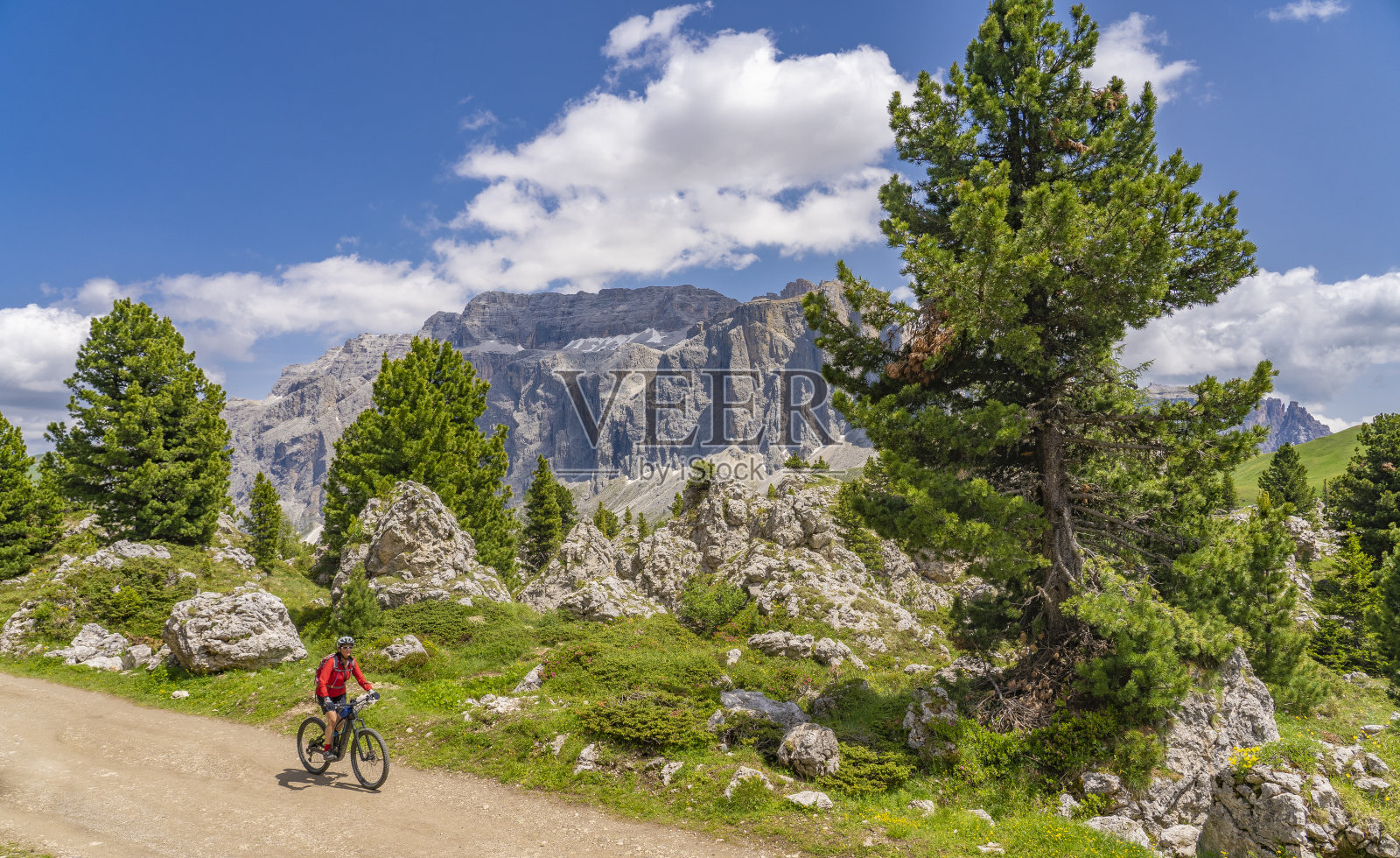 在石城里骑电动山地车的女人,Val Grdena照片摄影图片