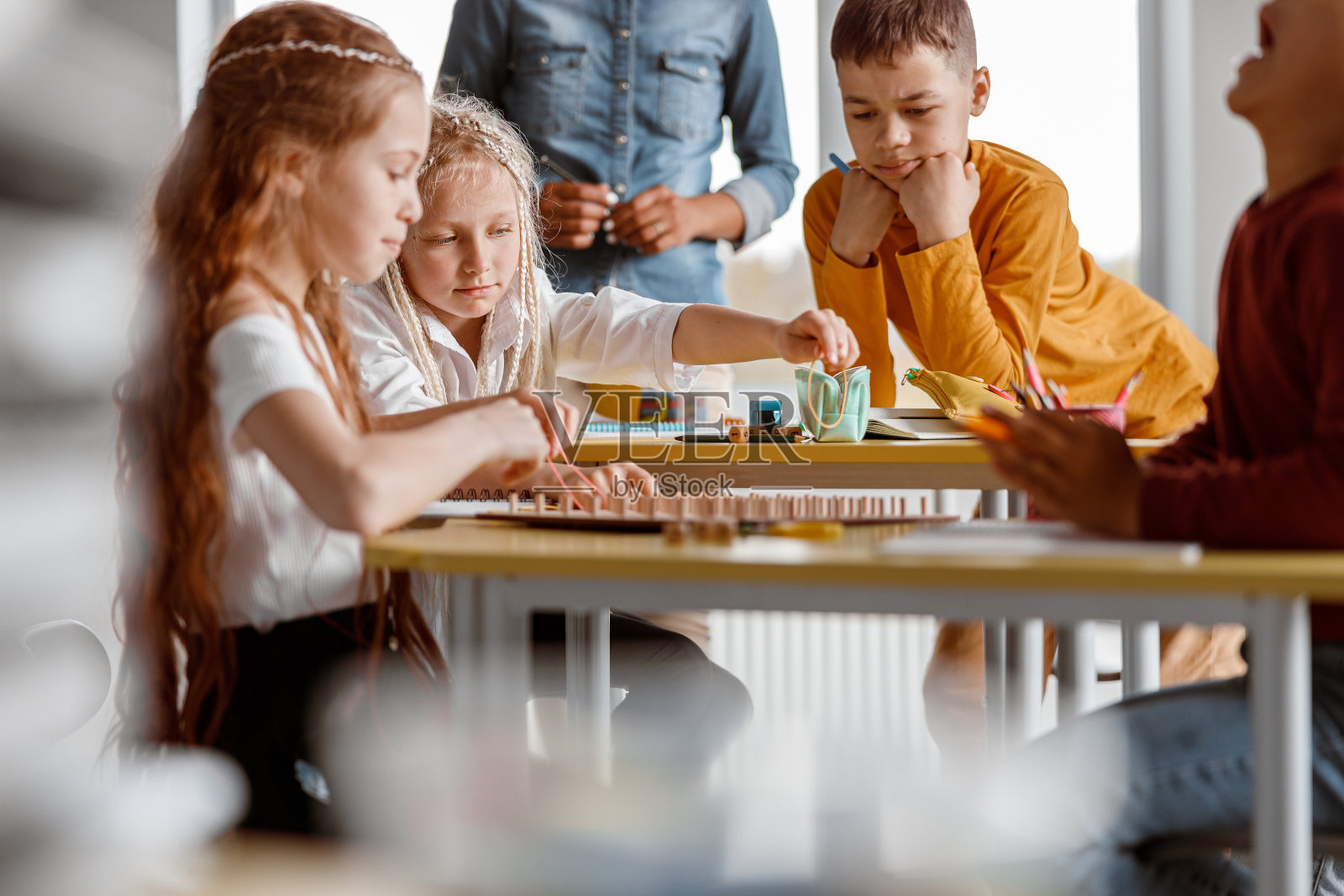 幼儿在学前班使用带橡皮筋的木制数学写字板进行实际练习照片摄影图片