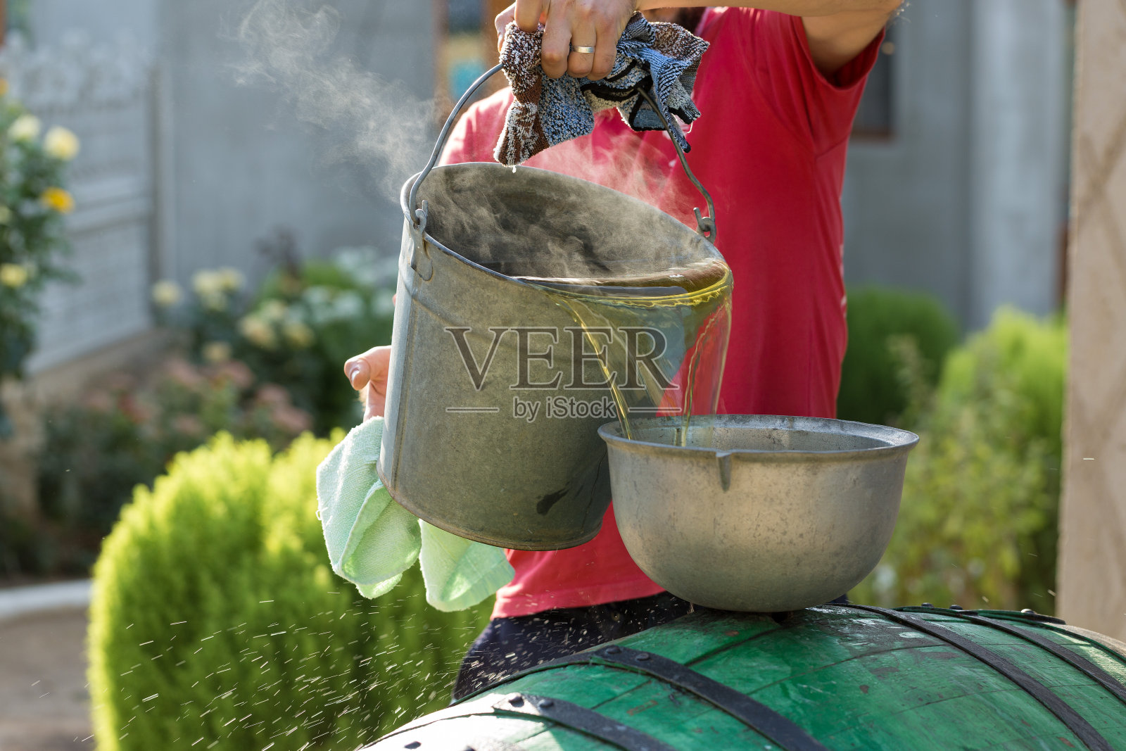 葡萄酒压榨与红色必须和螺旋螺旋。酿酒师的手合了起来。照片摄影图片