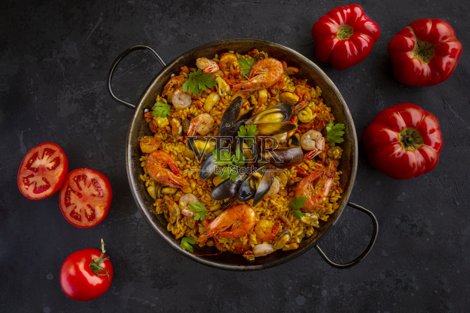 传统的西班牙海鲜饭配上黑色的西红柿照片摄影图片