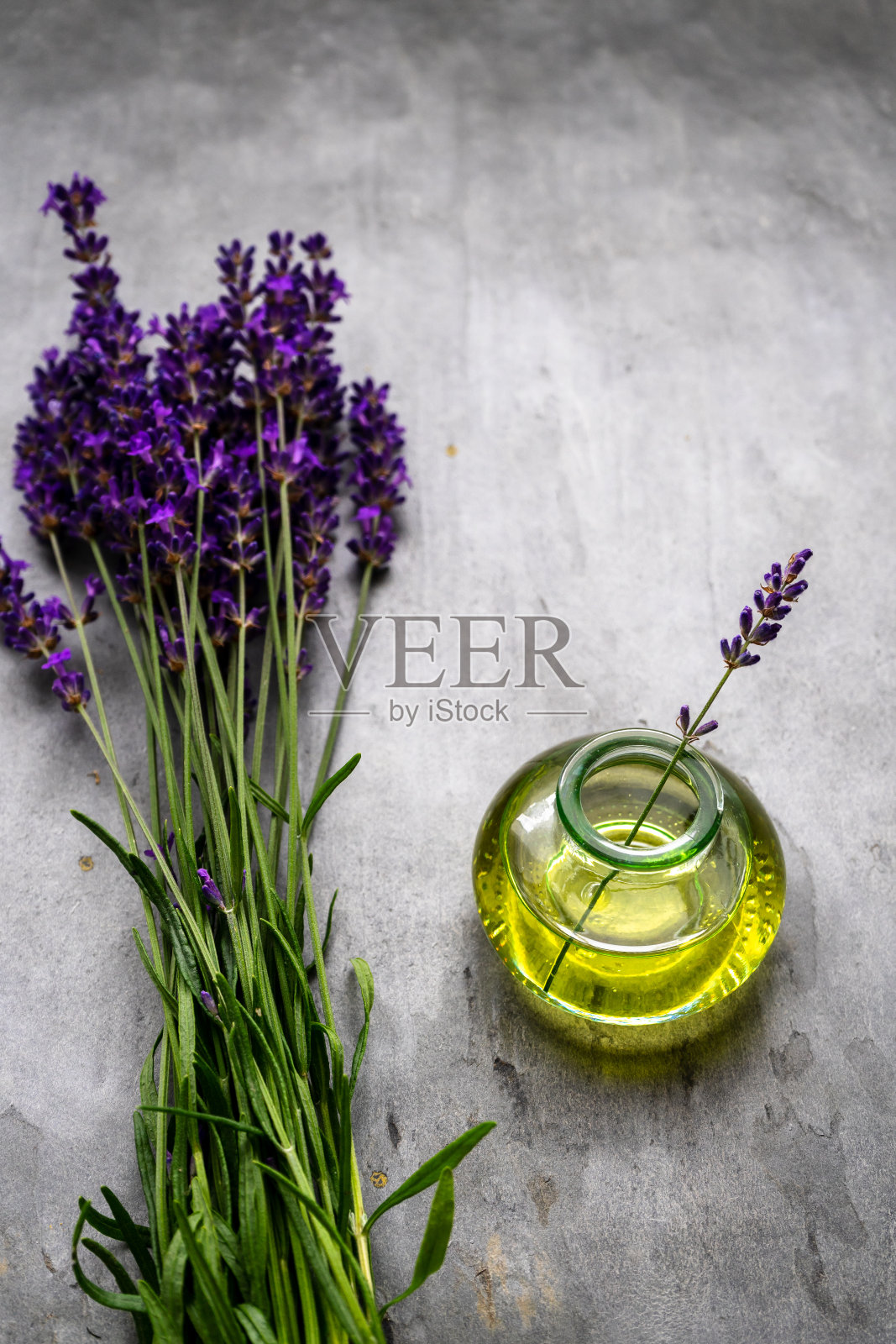 薰衣草油和一束新鲜薰衣草放在一张质朴的桌子上照片摄影图片