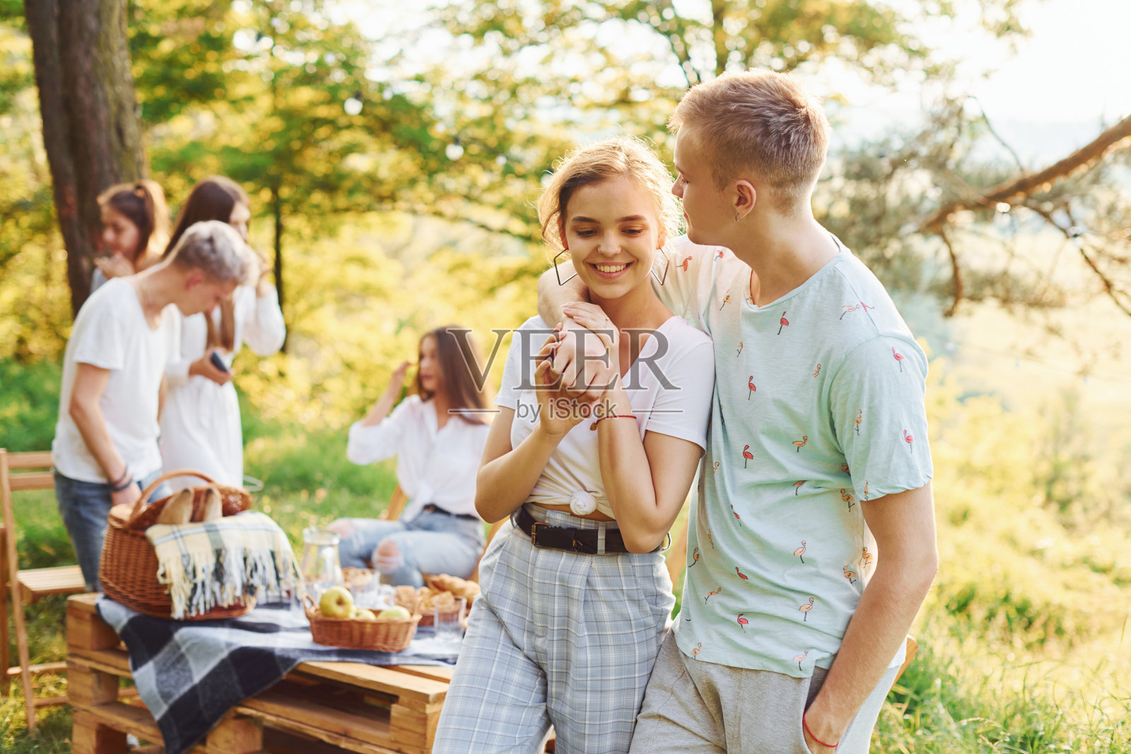 幸福的夫妻。一群年轻人在森林里户外度假。周末和友谊的概念照片摄影图片