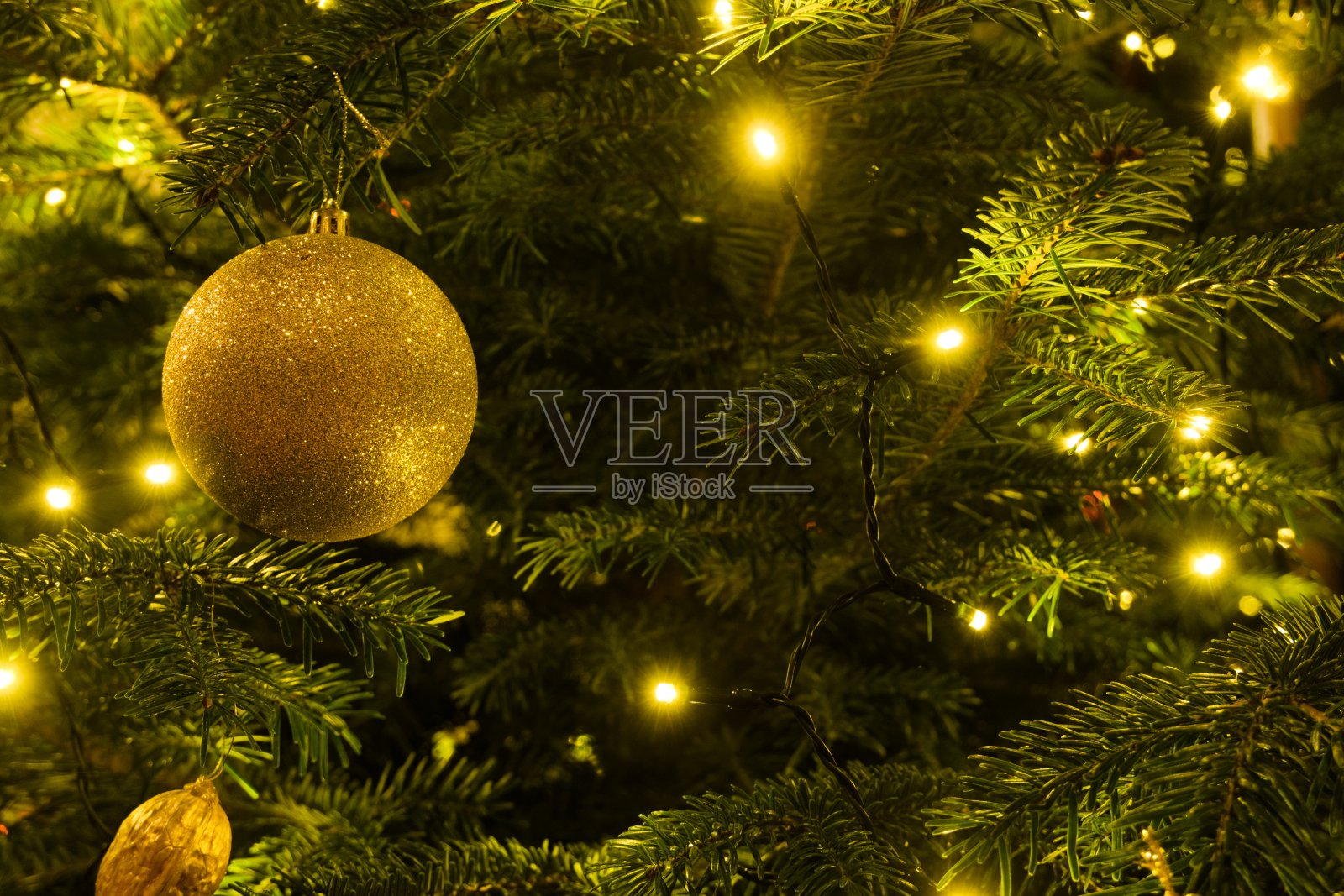 圣诞装饰,闪闪发光的球和温暖的灯垂下形成一个天然的树照片摄影图片