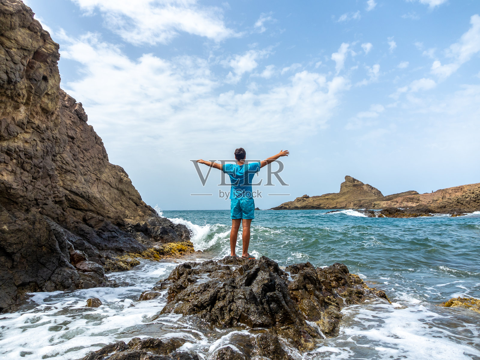 一个年轻人从后面望着地中海,一片蔚蓝照片摄影图片