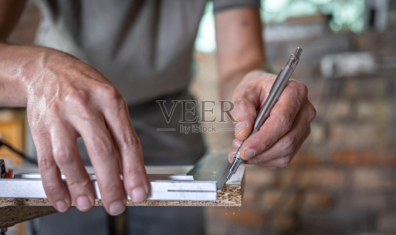 木匠用钢笔和尺子在这块木头上做记号。照片摄影图片