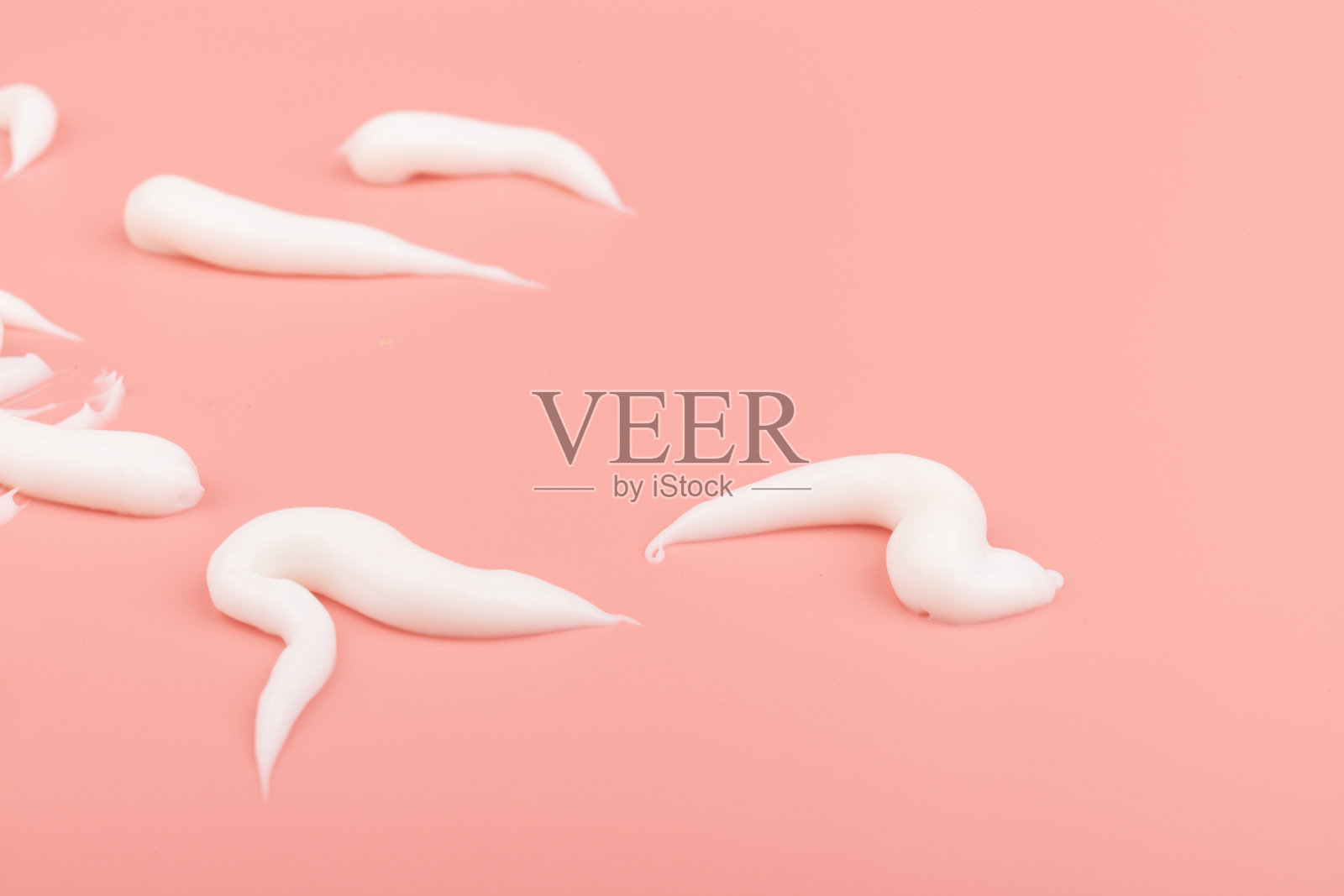 白色化妆品涂抹孤立在粉红色的背景。护肤产品质地细腻。照片摄影图片