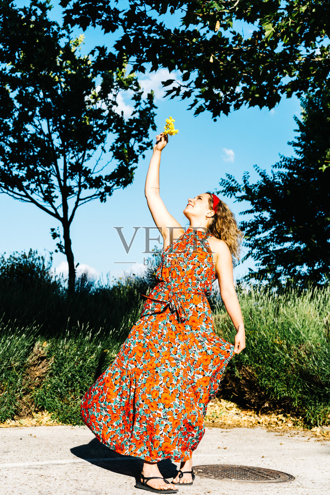 微笑的女人在一个炎热的夏天闻花的肖像照片摄影图片