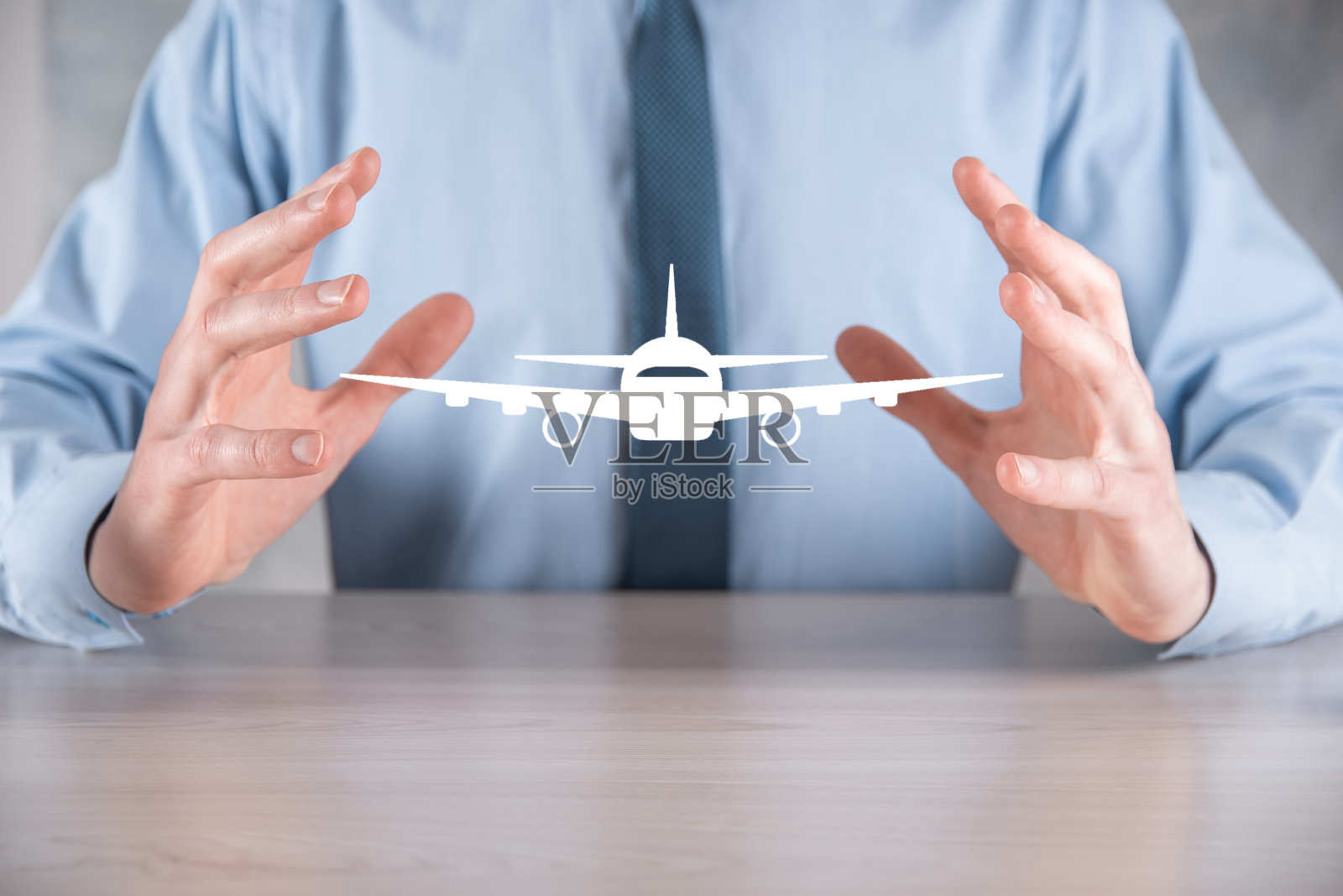 手里拿着飞机图标的商人。网上购买机票。旅行照片摄影图片