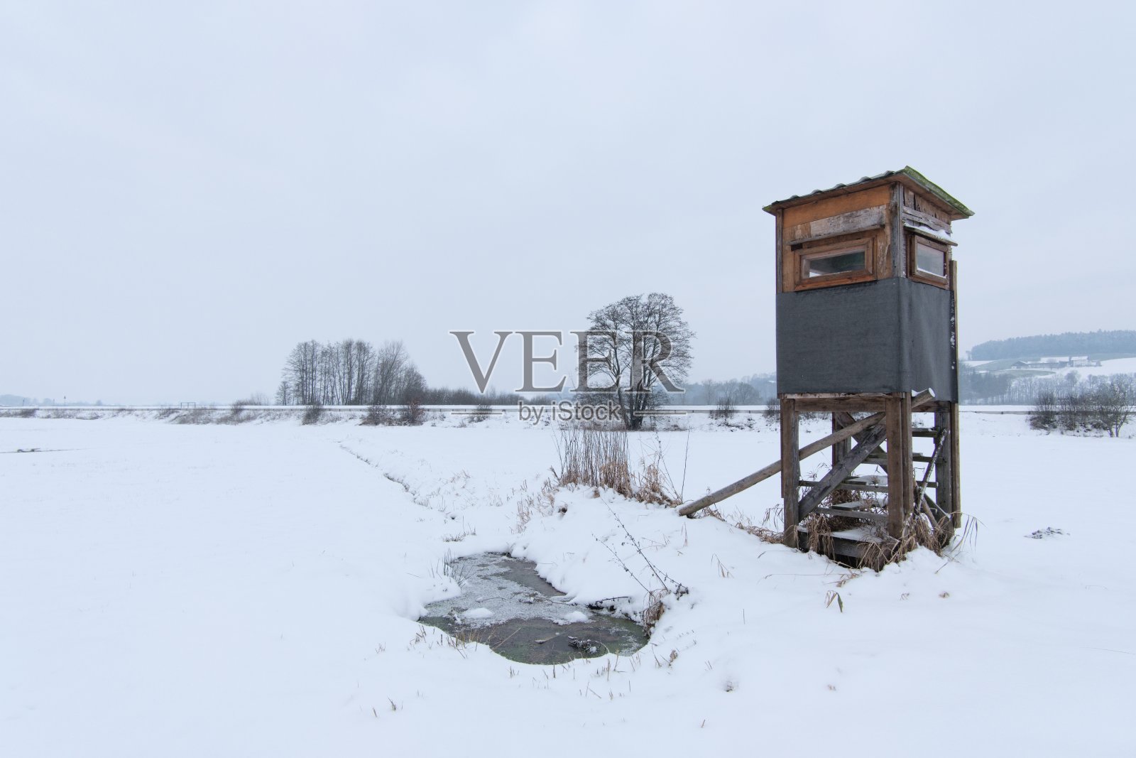 狩猎塔和自然观景台,又称狩猎站,坐落在冬季的雪景中间照片摄影图片