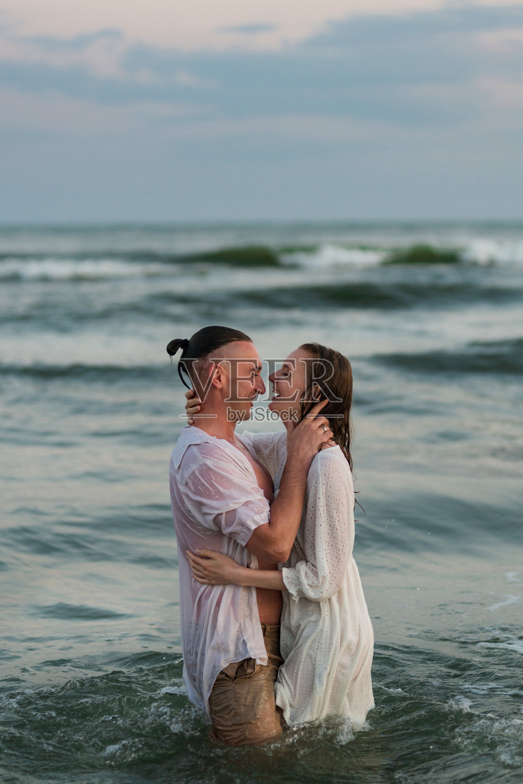 幸福的情侣在日落时分的海边漫步照片摄影图片