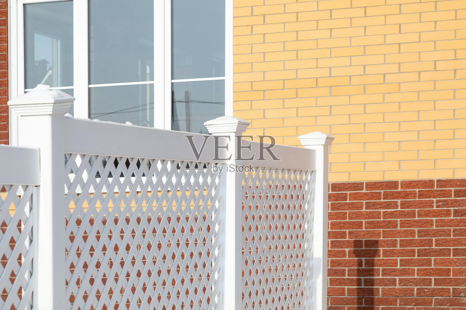 一个现代村舍里白色塑料栅栏的碎片。照片摄影图片