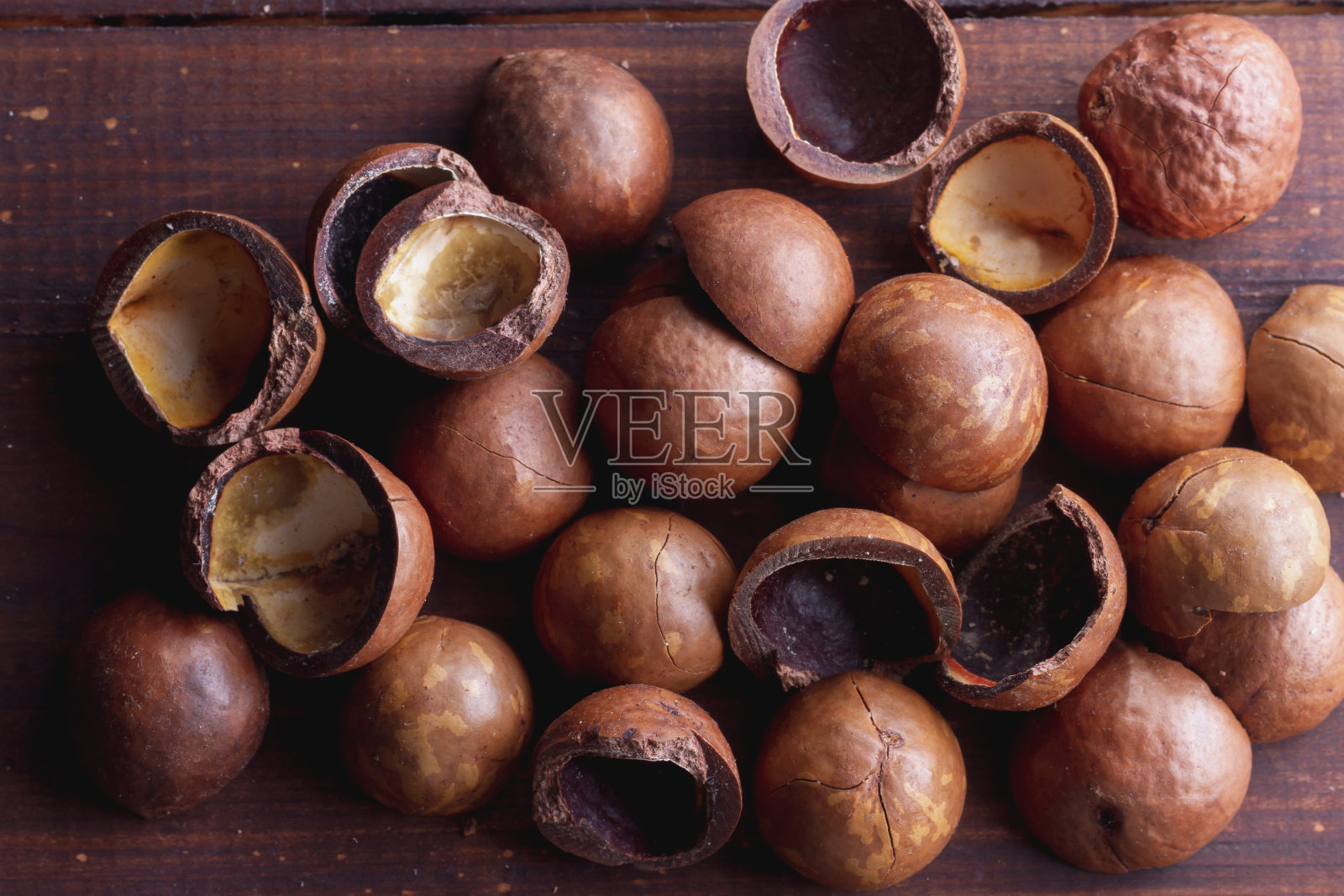 棕色的壳来自圆形的夏威夷坚果。背景照片摄影图片