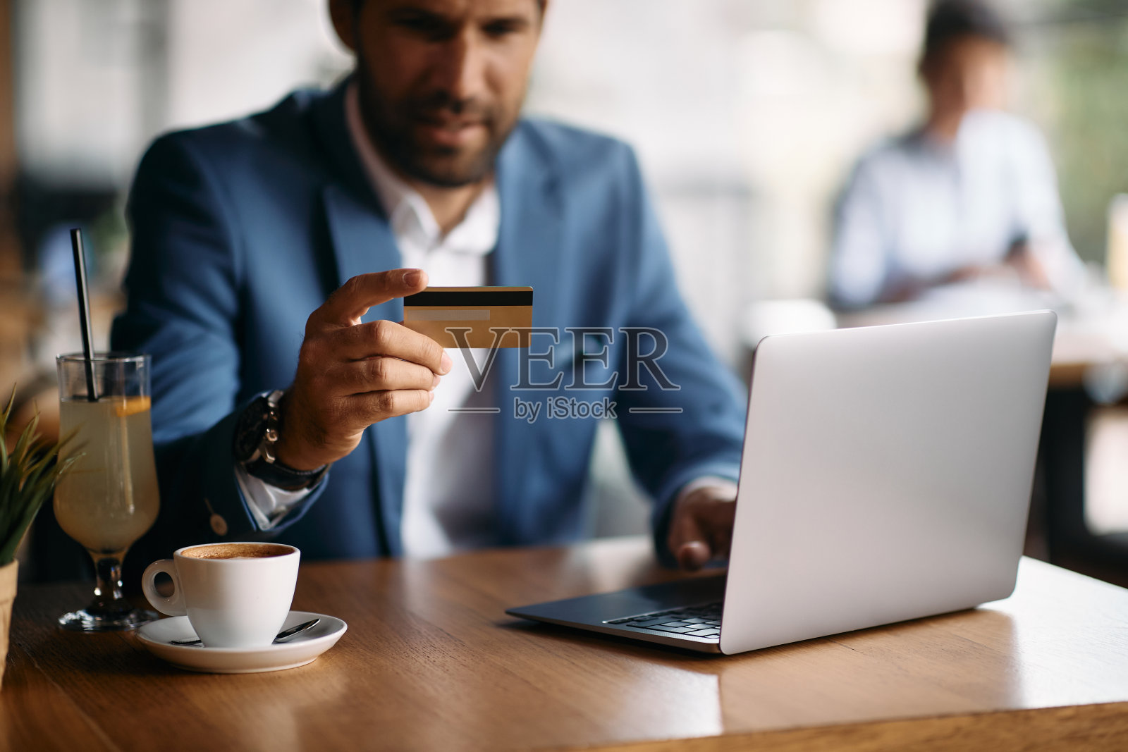 商人在咖啡馆使用信用卡和笔记本电脑的特写镜头。照片摄影图片