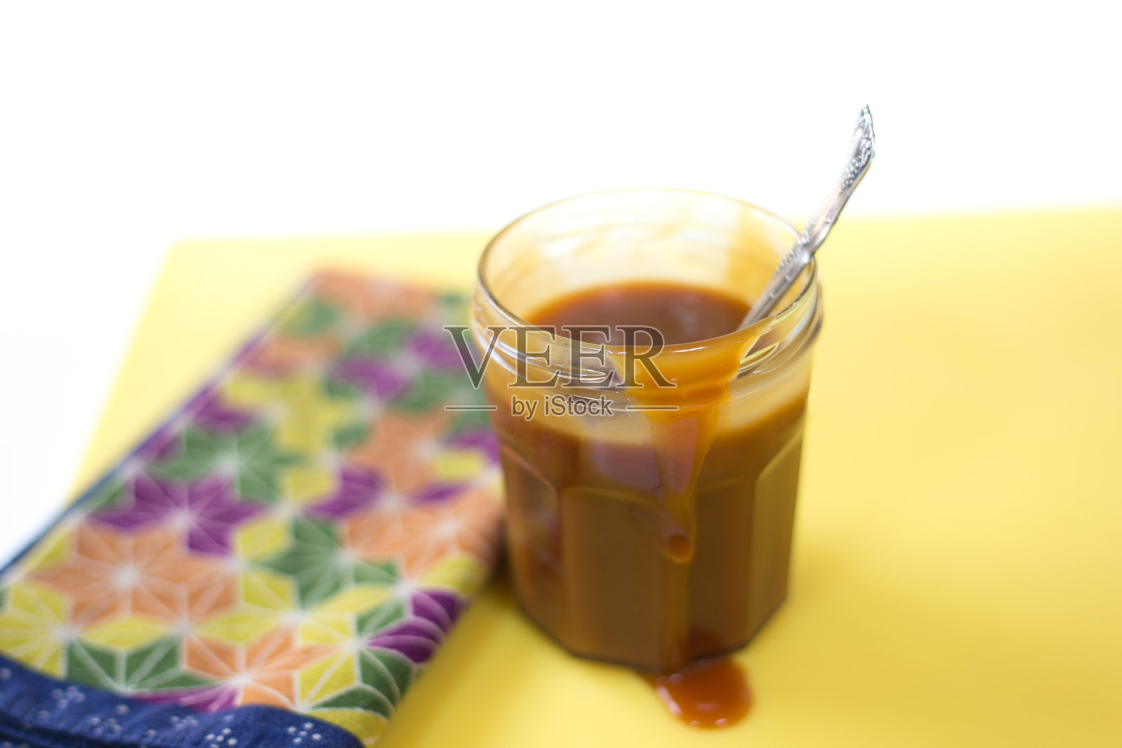 卡梅尔酱滴罐,勺子,餐巾照片摄影图片