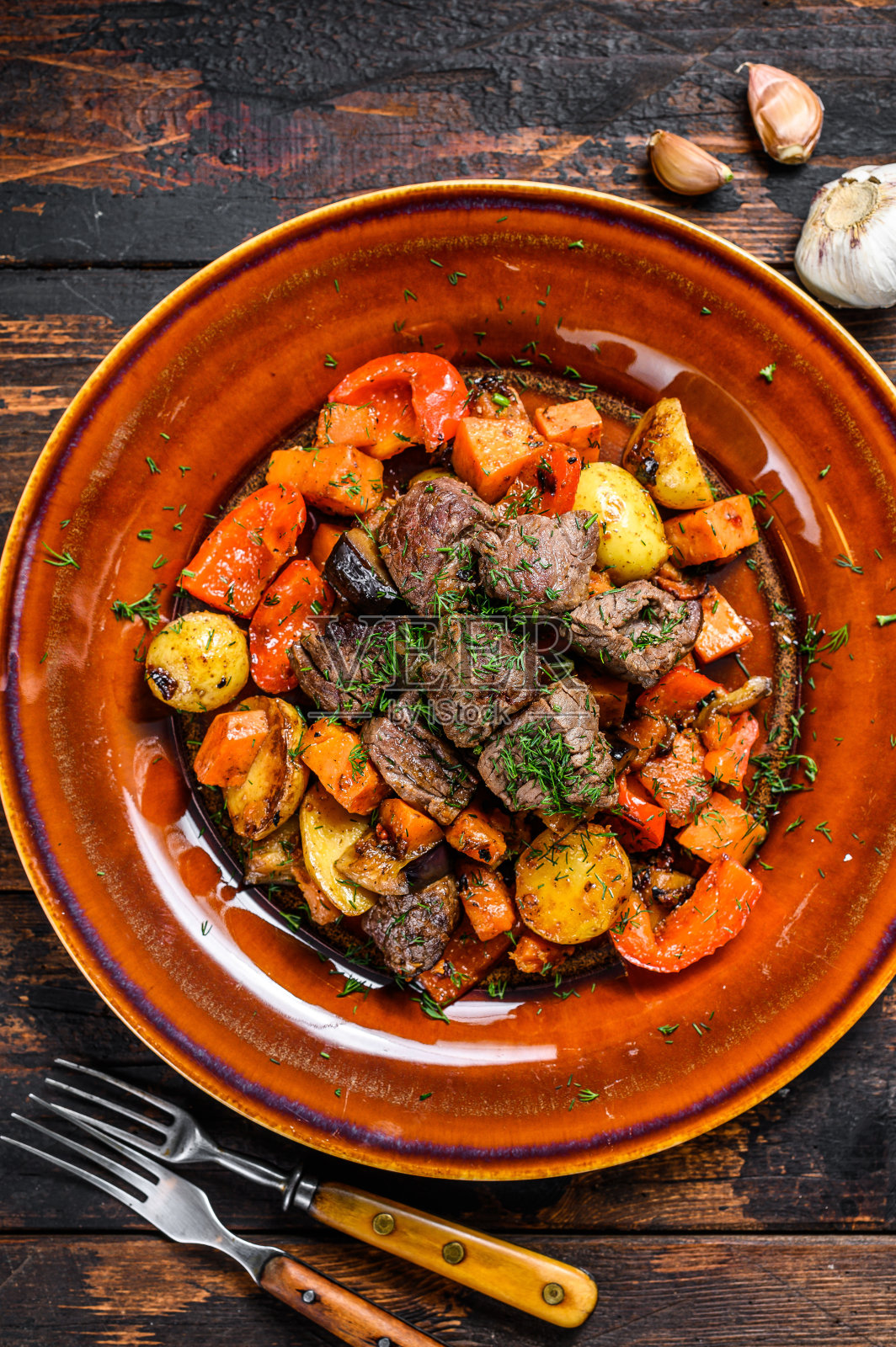 用牛肉、土豆、胡萝卜和香草做的爱尔兰炖菜。深色木制背景。俯视图照片摄影图片