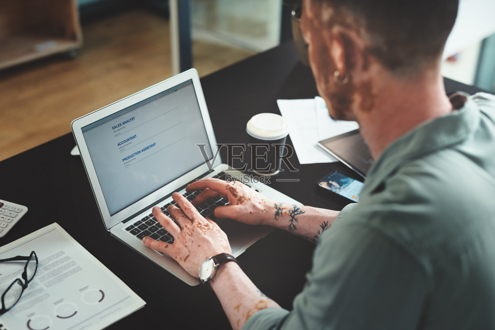 一个年轻的商人在办公室里用笔记本电脑工作照片摄影图片