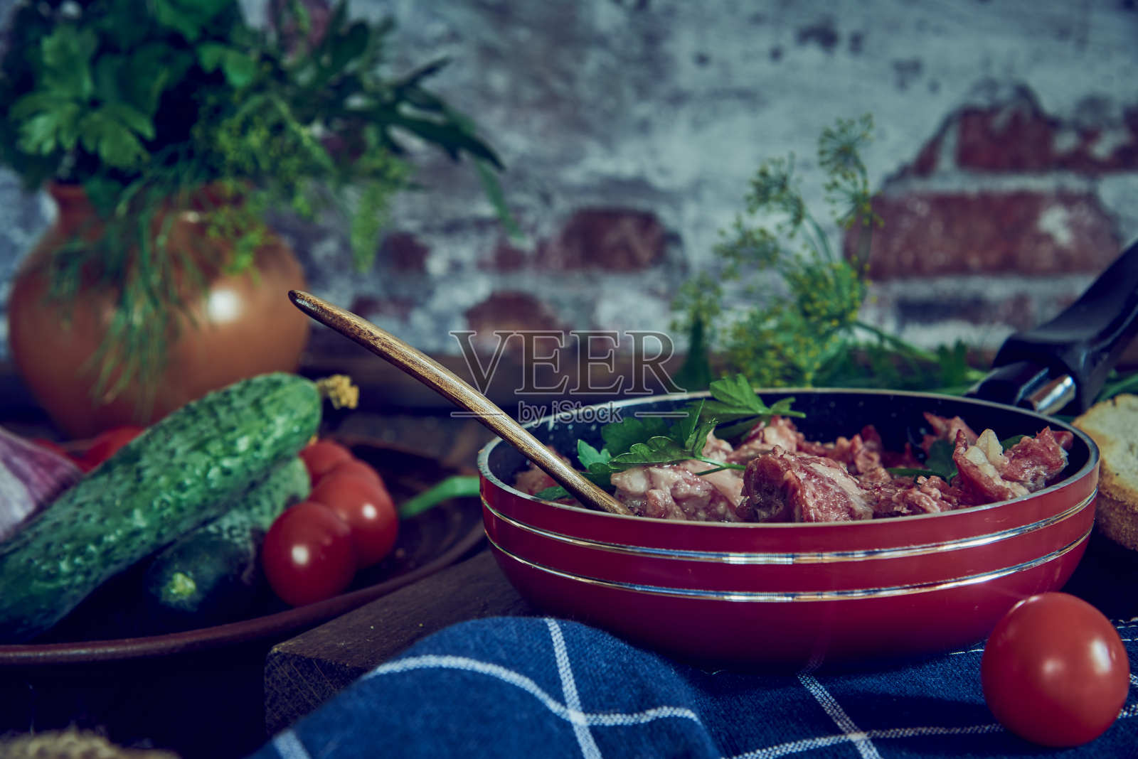 砖墙背景上的炖肉煎锅。照片摄影图片