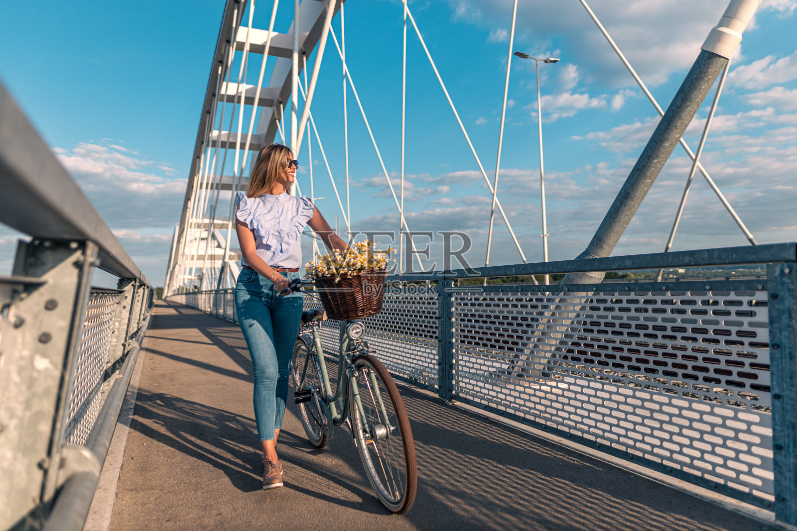 一个时尚的健康女人的全身肖像,去散步和推她的自行车照片摄影图片