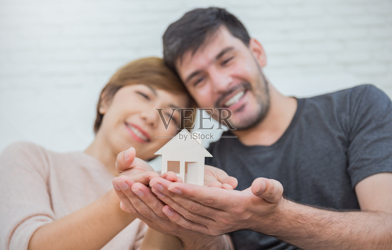 夫妻手握模型房子的特写肖像。男人和女人的手买新房子。一起爱创业新的家庭业主概念照片摄影图片