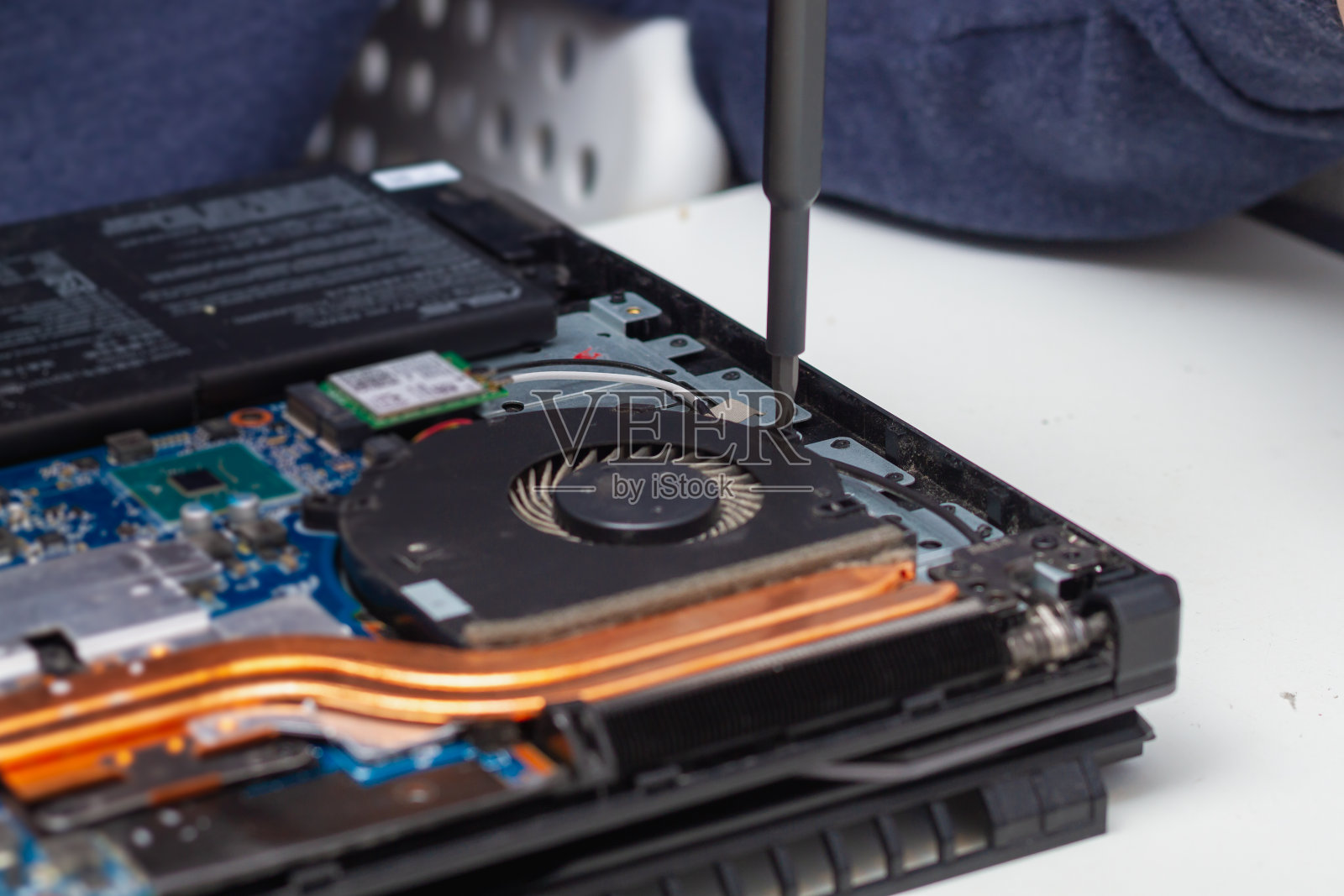 一名办公设备修理工拆开一台笔记本电脑查找故障照片摄影图片