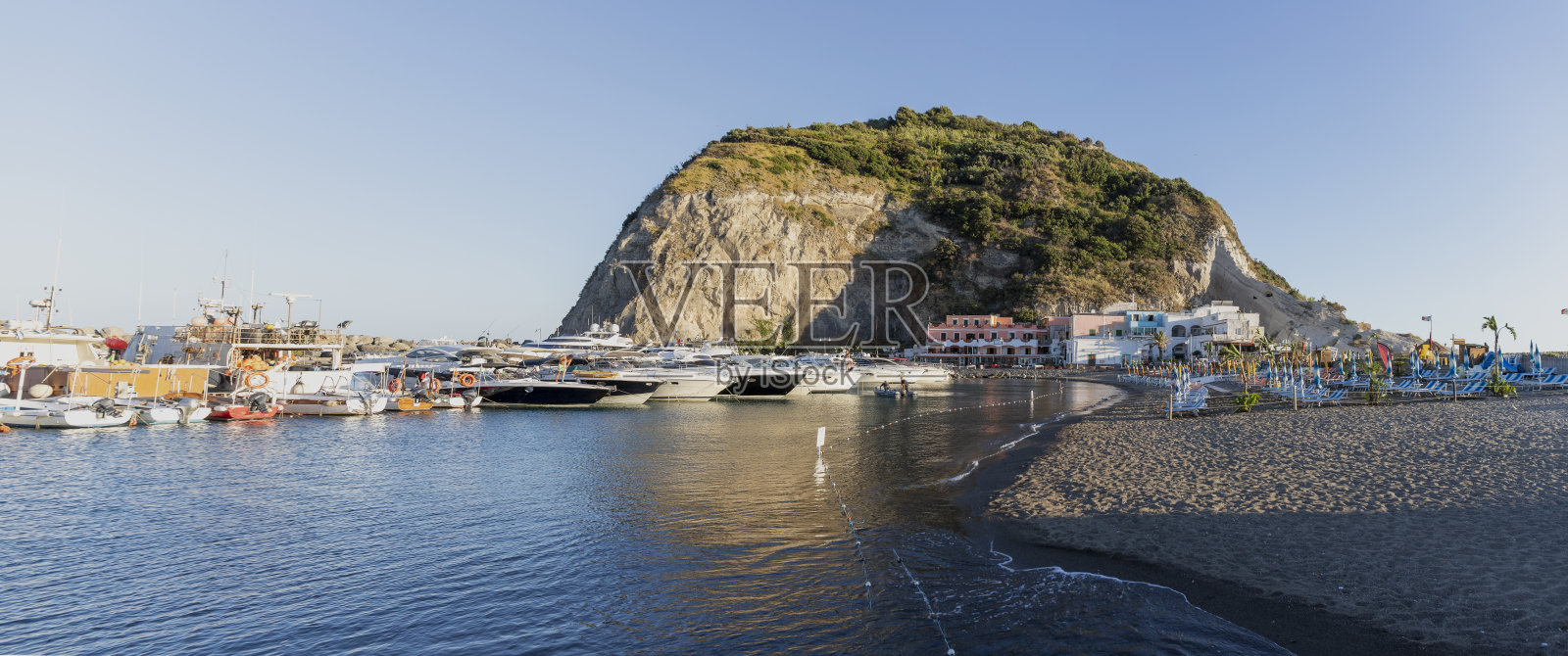 伊斯基亚圣安杰洛村的海滩和港口。日落时岛上的小船和海滩。照片摄影图片