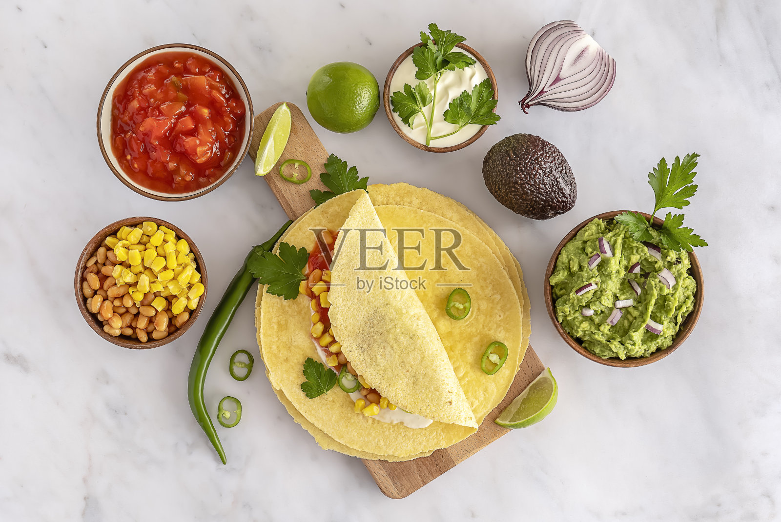 玉米粉圆饼或玉米卷,豆类,绿色蔬菜,和自制的鳄梨酱。照片摄影图片