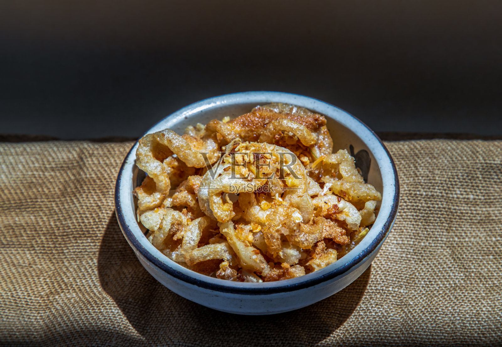 猪油炒猪皮或瓷碗炒猪皮。这是一道美味的开胃菜。照片摄影图片