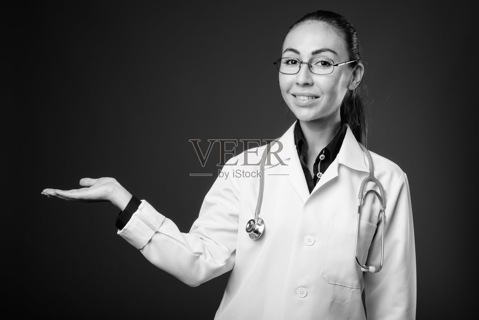 摄影室拍摄的年轻美丽的女医生与眼镜照片摄影图片